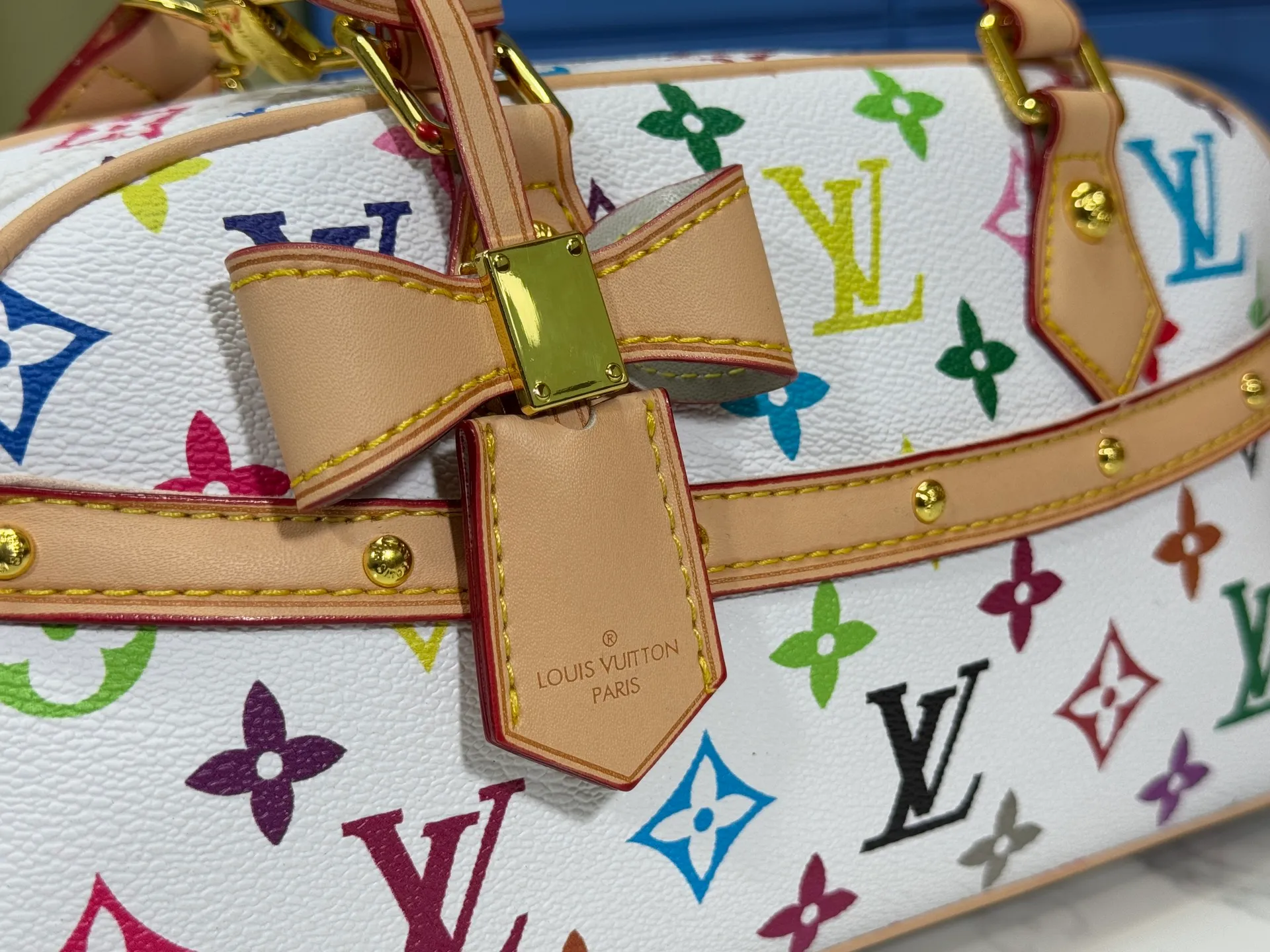 P300 Upgraded Original M13084 This Handbag East West handbag is from the Louis Vuitton x Takashi Murakami reissue series, using the artist's signature rainbow tones to trace the full-length Monogram pattern. Sleek horizontal construction lines the top handle, studded side straps, detachable and adjustable shoulder strap and LV x TM key holder, with cowhide leather details and sophisticated corners that nod to the brand's traditional luggage. Dimensions: 27.0 x 14.0 x 10.0 cm (length x height x width)