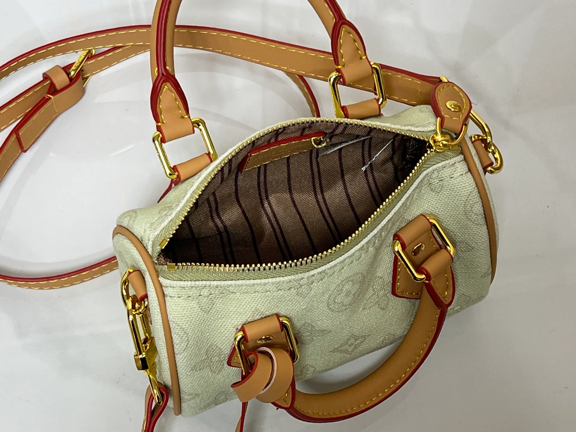 Batch 240💰M28322 Red M28323 M27610 M81085 [Exclusive background shot] This Nano Speedy handbag condenses the configuration of Louis Vuitton's classic Speedy handbag. It is made of Monogram canvas with distressed cow leather details and dazzling metal parts, making it easy to carry with you for daily needs. The handles and removable and adjustable shoulder strap allow for a variety of styling possibilities. 16.0 x 10.0 x 7.5 cm (L x H x W) • Monogram coated canvas • Cow leather trim • Metal hardware • Zipper closure • Space to store daily necessities such as a 6.1-inch smartphone, card holder and lipstick • Shoulder strap: removable, adjustable • Half-length strap: 45.5 cm • Half-length strap adjustable to: 54.0 cm • Handle: Double handle