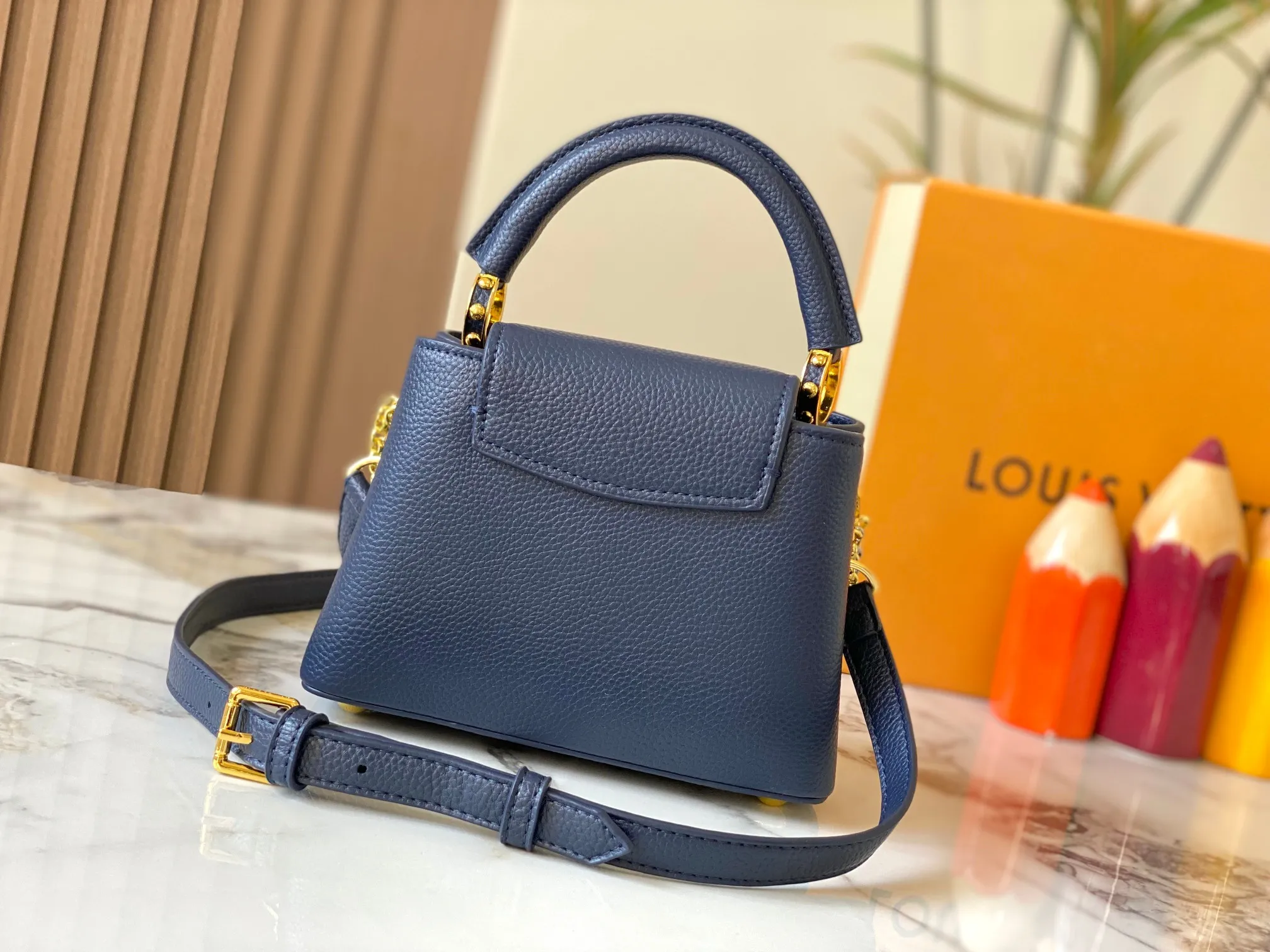 P480 [Guangzhou top quality original version] M26351 Blue This modern version of the Capucines mini is made of timeless Taurillon leather and equipped with a jewelry-inspired Infinity chain. The bag is decorated with double galvanized metal parts, including the iconic Monogram floral pattern, and the LV Initials logo created with sunburst technology, creating a sundial-like light and shadow effect. The bag has multiple pockets and a detachable shoulder strap, allowing it to be carried on one shoulder or across the body. 14 x 8 x 21 cm (height x width x length)
