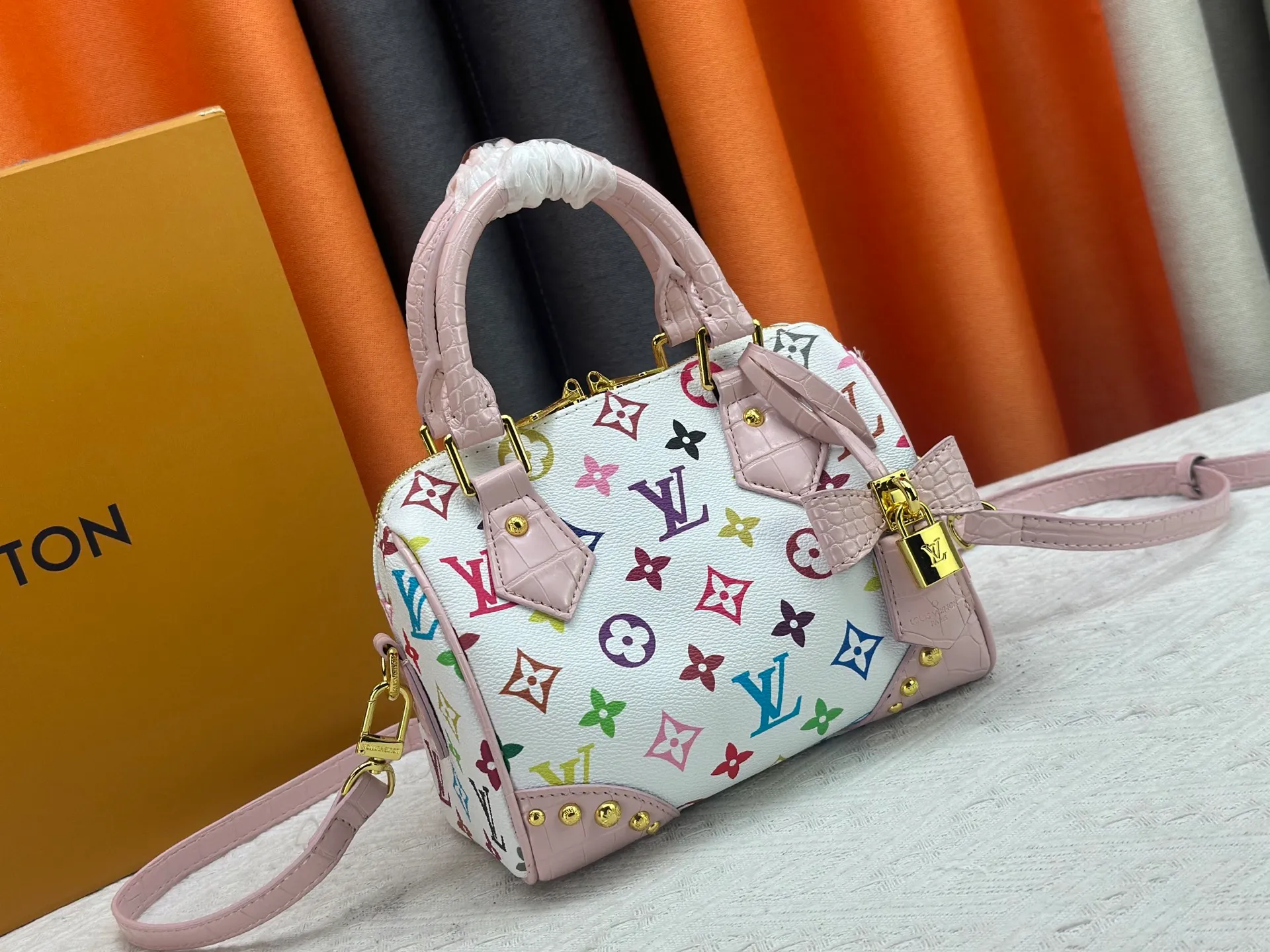 P260 Upgraded original crocodile pattern M13365 M58953 M46234 M46222 Speedy Bandoulière 20 handbag is made of soft coated canvas, and the full-length Monogram pattern is traced in colorful rainbow tones, highlighting the smart style of the Louis Vuitton x Murakami reissue series. The Toron handle and detachable shoulder strap are constructed of cow leather, the metal corners recall classic luggage elements, and the bow-shaped key bag and padlock add brand touches. Dimensions: 20.5 x 13.5 x 12.0 cm (length x height x width)