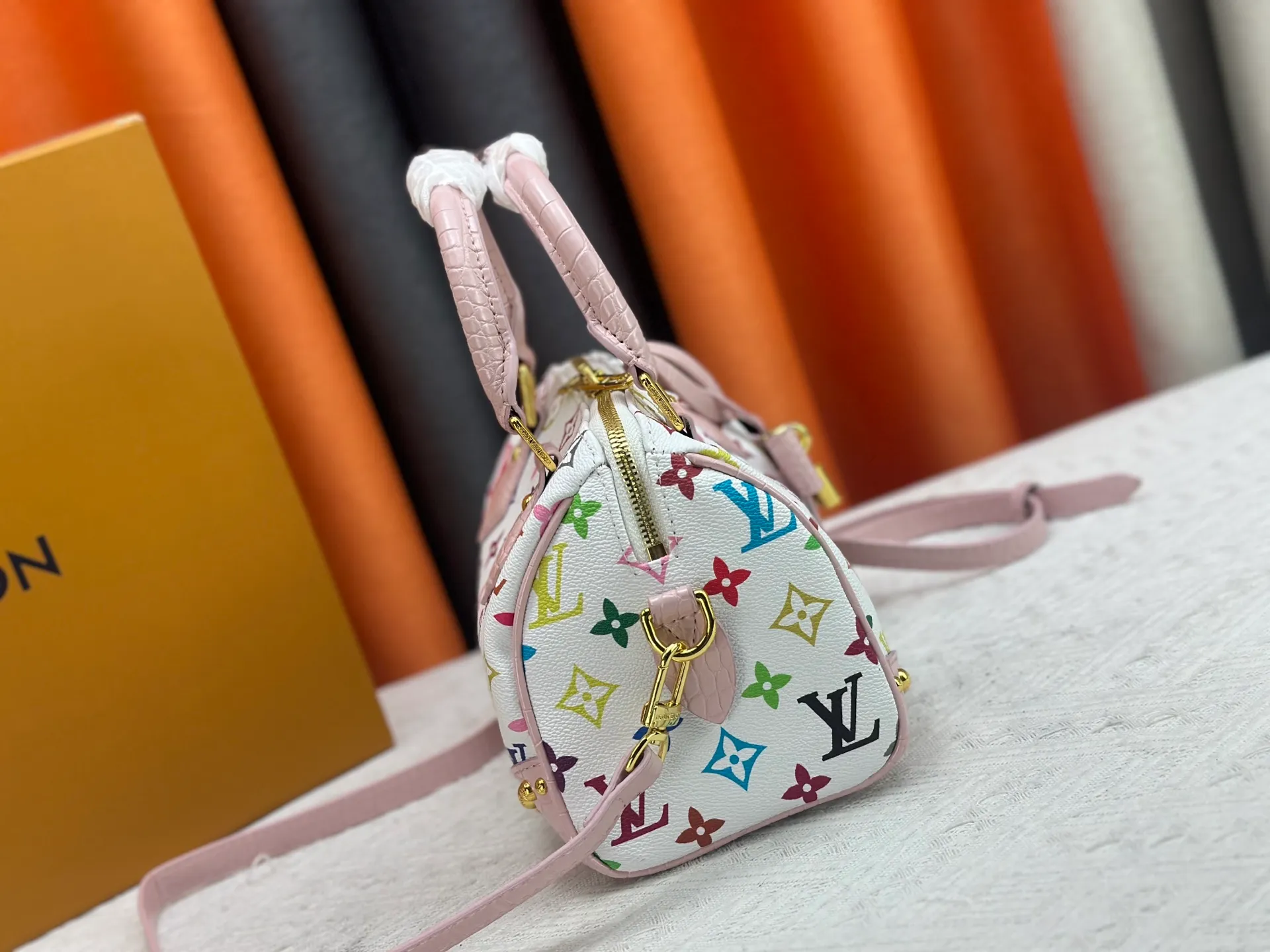 P260 Upgraded original crocodile pattern M13365 M58953 M46234 M46222 Speedy Bandoulière 20 handbag is made of soft coated canvas, and the full-length Monogram pattern is traced in colorful rainbow tones, highlighting the smart style of the Louis Vuitton x Murakami reissue series. The Toron handle and detachable shoulder strap are constructed of cow leather, the metal corners recall classic luggage elements, and the bow-shaped key bag and padlock add brand touches. Dimensions: 20.5 x 13.5 x 12.0 cm (length x height x width)
