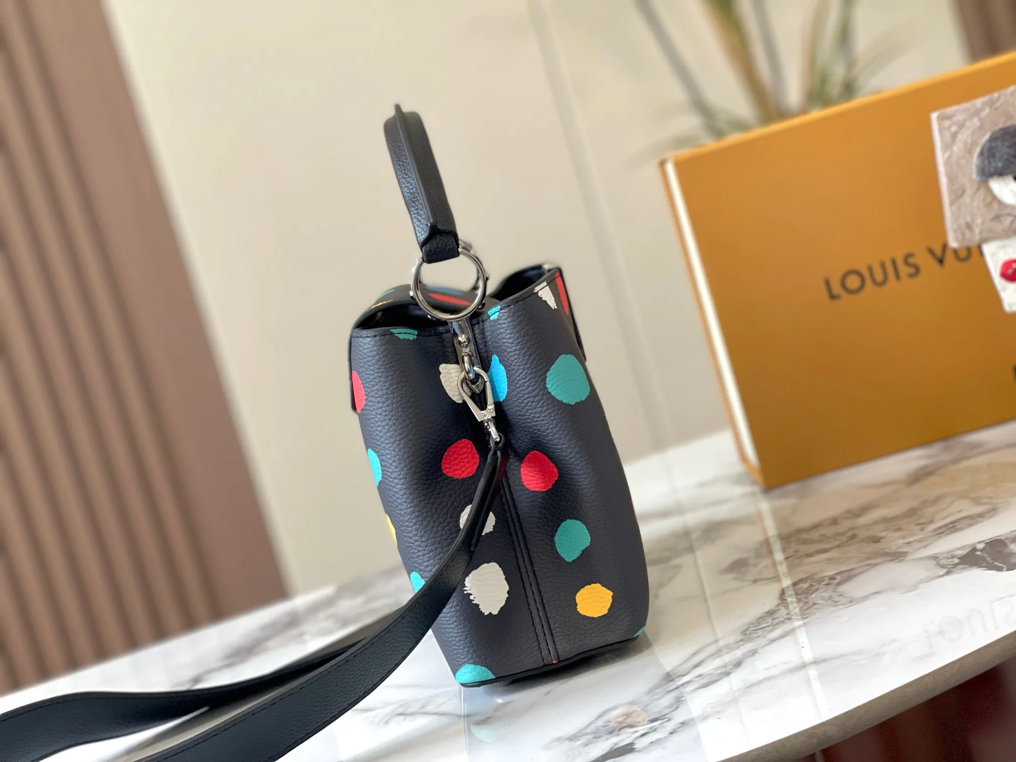 Upgraded version P440 M21663 This LV x YK Capucines small handbag comes from the Louis Vuitton x Yayoi Kusama collaboration series. The renowned Japanese artist has been obsessed with polka dots as a symbol of infinity since childhood, and finds a dazzling expression in supple Taurillon leather decorated with 3D hand-painted polka dot prints. Detailed features 27 x 18 x 9 cm (length x height x width)