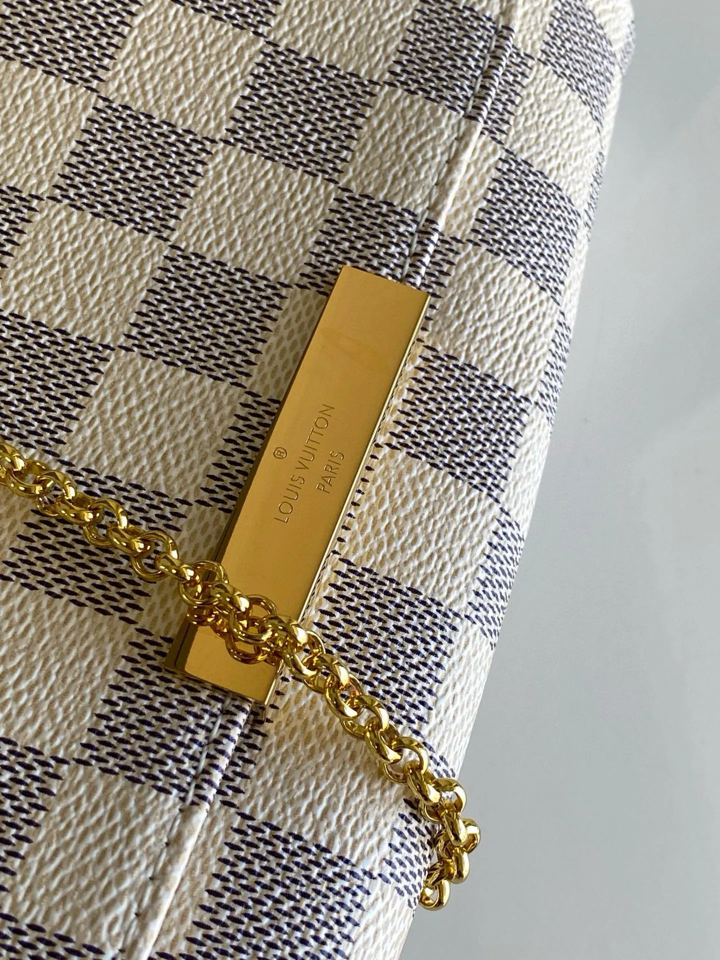 💰600 Top original item N41277 FAVORITE MM This Favorite MM handbag is the darling of fashionable women. It is sewn with bright Damier Azur canvas and is suitable for both morning and evening occasions. The bag can be used as a clutch, or can be carried as a short shoulder bag using the gold chain strap, while the leather shoulder strap can be easily carried cross-body. An engraved metal plaque on the front conceals a clever magnetic closure for safe access. Details 24x 14x 4 cm (length x height x width) Damier Azur coated canvas Natural cowhide leather trim Textile lining Gold-tone hardware Magnetic flap closure Internal patch pocket Shoulder strap: non-detachable, not adjustable Strap height: 52.0 cm Chain strap: detachable