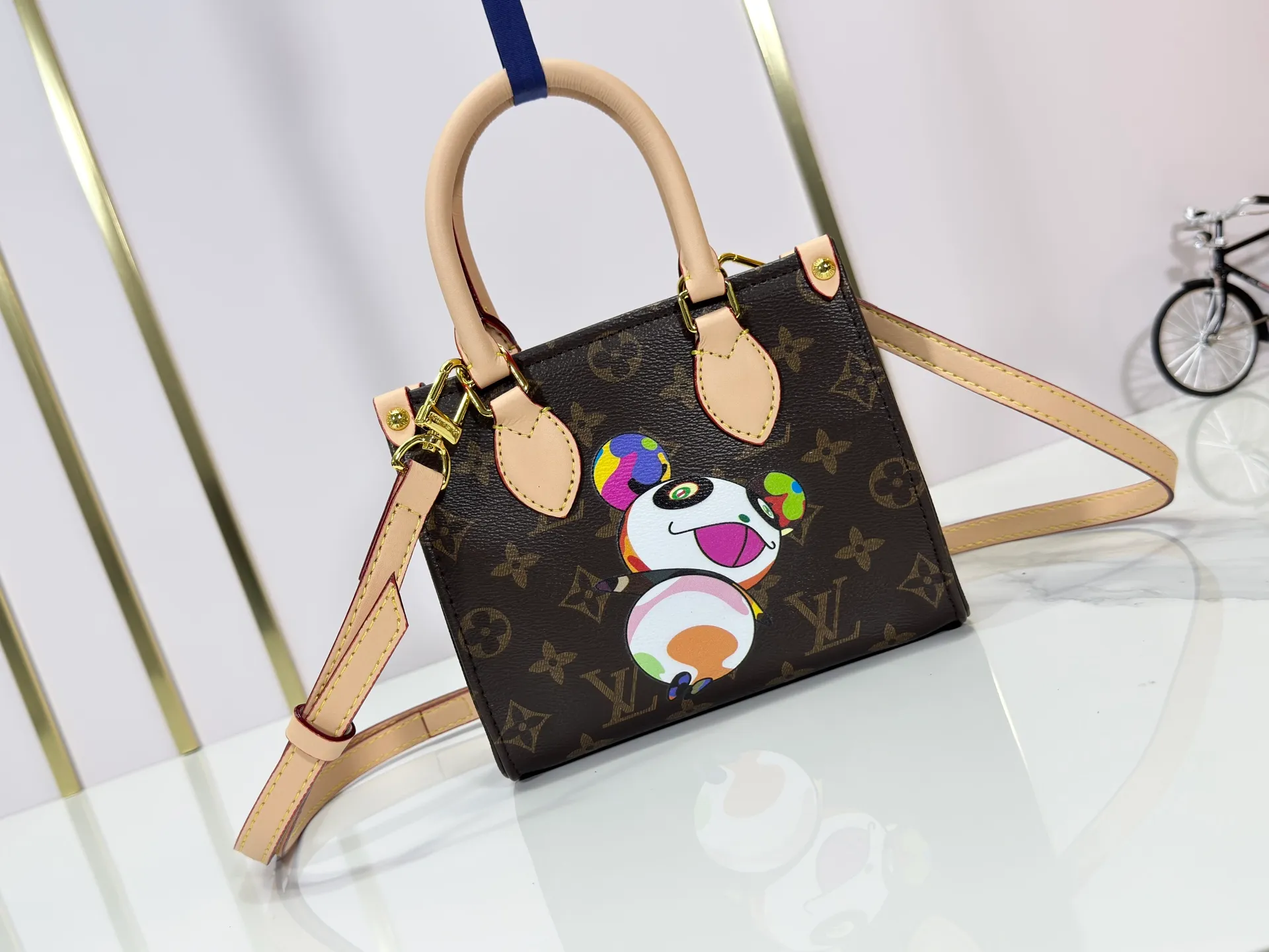 P220 upgraded original M13668 M46839 Louis Vuitton x Murakami reissue series interprets the exquisite version of the OnTheGo handbag with playful touches. Monogram canvas and cow leather establish the brand's classic style, and Murakami's cute and cute panda image is transformed into front and back prints. The detachable and adjustable shoulder strap provides a variety of carrying options, and the zippered interior pocket keeps personal items safe and secure. Dimensions: 18.0 x 15.0 x 8.5 cm (length x height x width)