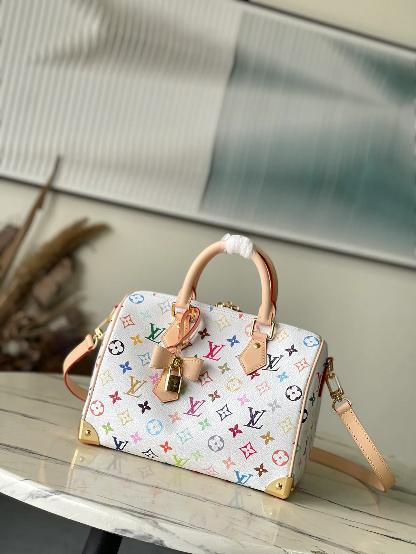 💰1140 Top original order M13085 This Speedy Bandouliere25 handbag renders the classic Monogram pattern with the bright colors of Japanese artist Takashi Murakami. Together with the bow-shaped key bag, it highlights the smart style of the Louis Vuitton × Murakami collaboration series. The Toron handle and detachable and adjustable shoulder strap are fashioned from calf leather, and the dazzling padlock and corners are a reference to the brand's luggage elements. Dimensions: 25 × 19 × 15 cm