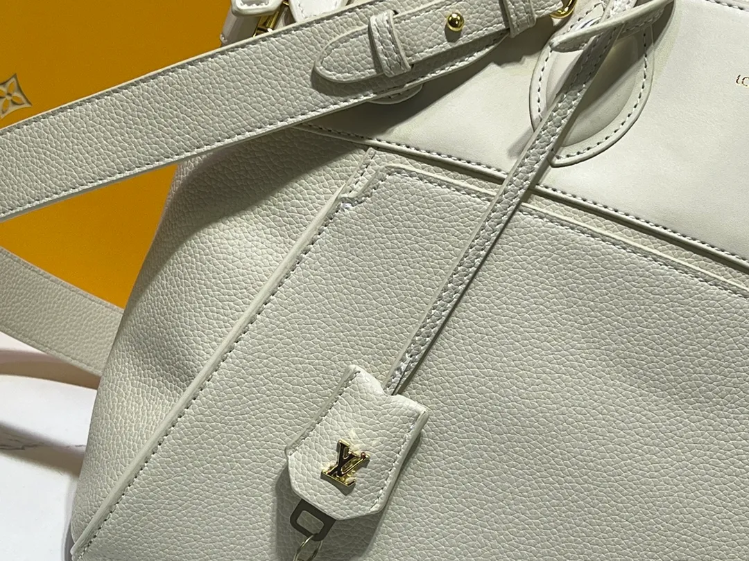 Batch 340💰M11214 green M22914 black M22925 brown M23061 off-white M22927 taupe. Sophisticated and functional, the Lock It MM bag is crafted in fine grained Taurillon leather and smooth calfskin, with gold-finish buckles and hardware. Signature House touches include padlocks, key bells and hot-stamped Louis Vuitton signatures. Featuring an articulated top handle and removable strap, this tote offers a variety of carrying options. 36x29x15 cm (LxHxW) Black Taurillon leather, smooth calfskin semi-leather trim Microfiber lining Gold hardware 2 square buckles padlock key bell External pockets 2 internal flat pockets Internal zipped pocket with flat pockets 5 protective metal studs Strap: removable, adjustable Strap drop: 45.0 cm Maximum strap drop: 51.0 cm