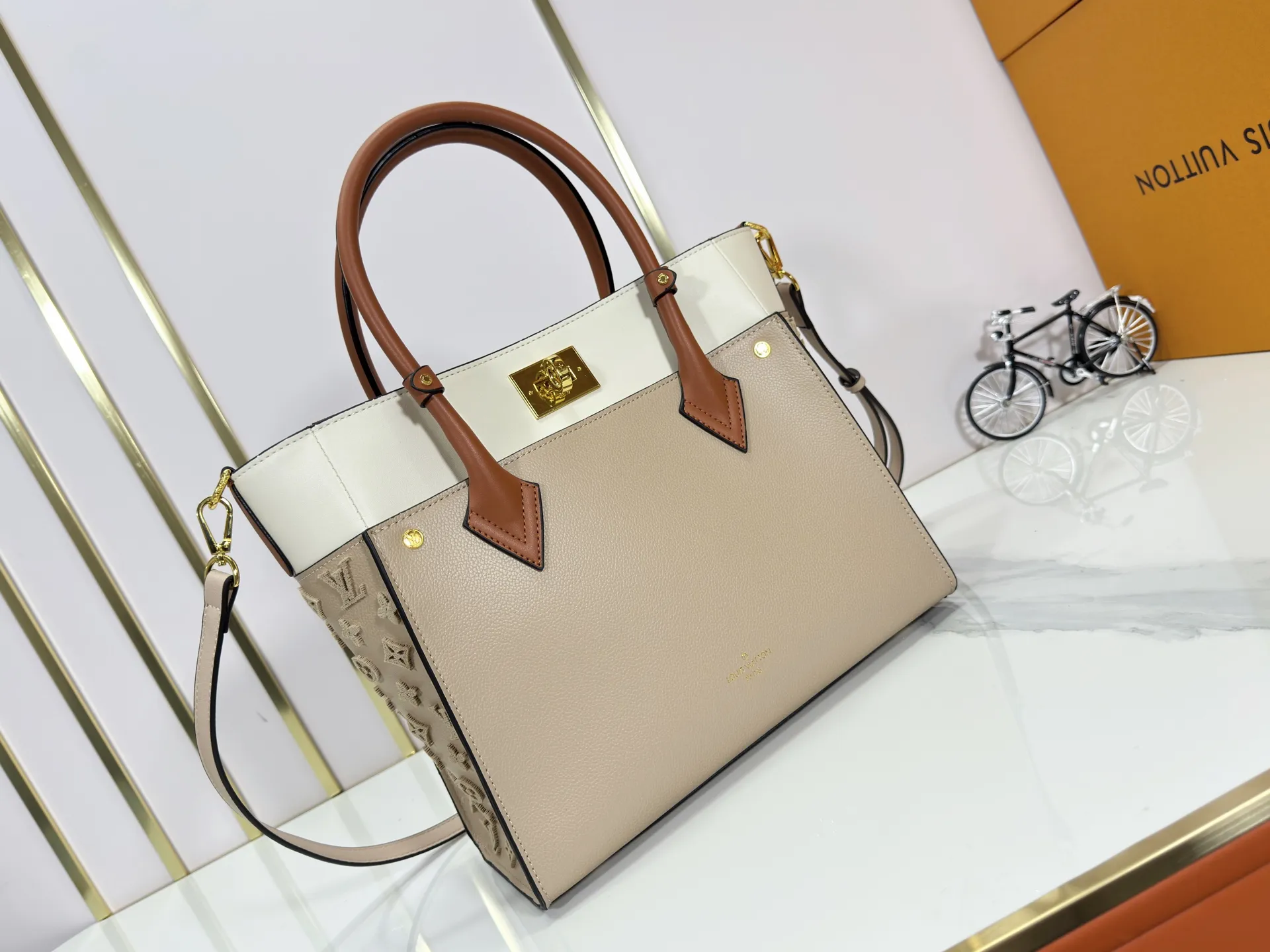 P360 upgraded original M53826 M53826 M53825 M53824 M53823On My Side handbag shows the elegant fusion of calfskin and classic Monogram canvas. Contrasting canvas shapes the large outer pocket, creating a trompe l'oeil effect as if two handbags merge into one. Plenty of space can easily accommodate office needs, and the adjustable shoulder strap allows for a cross-body style. Dimensions: 30.5 x 24.5 x 14 cm (Length x Height x Width) - Calfskin and Monogram coated canvas - Cowhide leather trim - Microfiber lining - 2 top handles for hand or elbow carry - Adjustable shoulder strap for shoulder or cross-body wear - Lock closure - 2 outer pockets with magnetic closure - Zip pocket - 1 patch pocket
