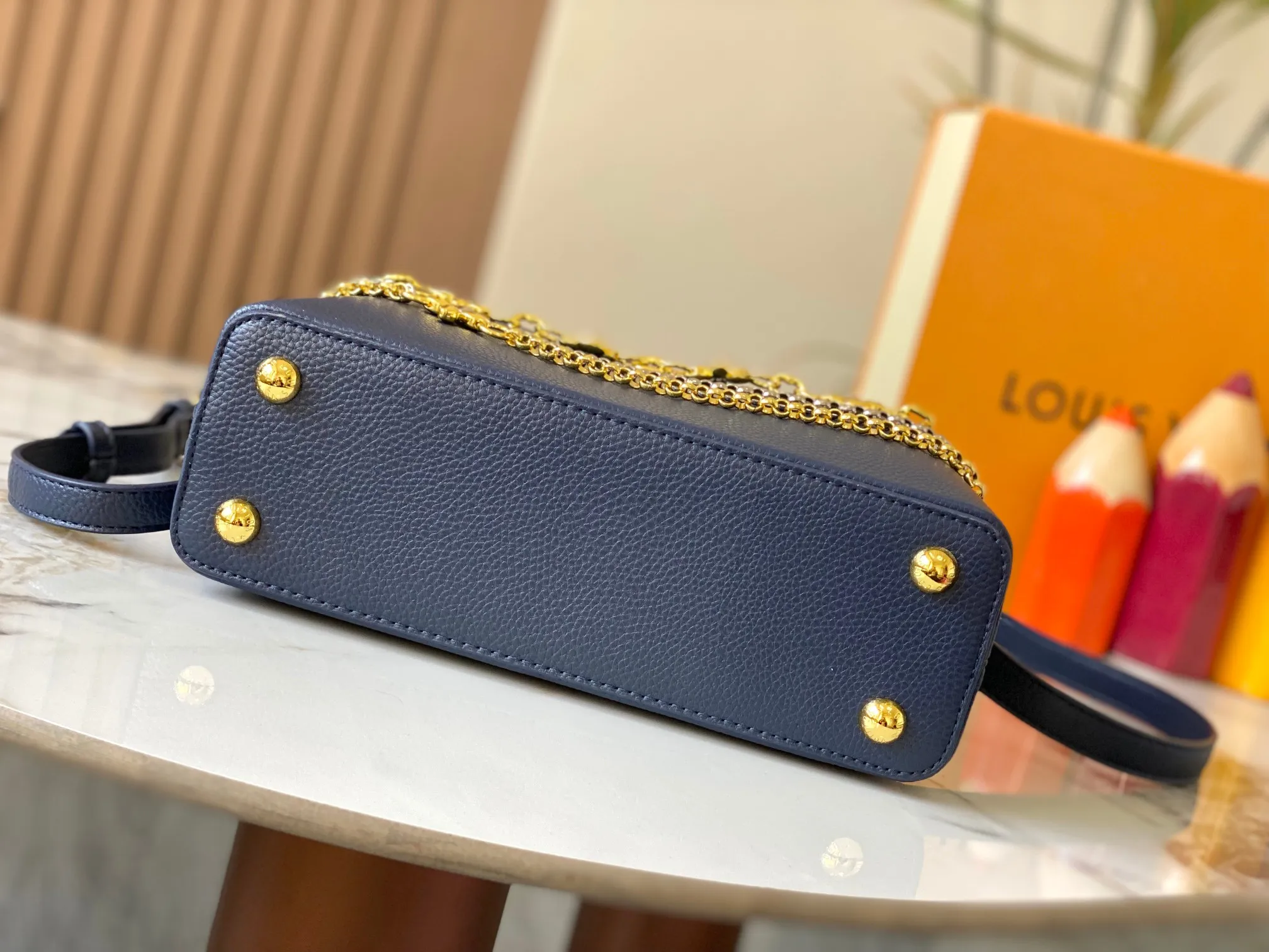 P500 [Guangzhou top quality original version] M26532 Blue This modern version of Capucines BB is made of timeless Taurillon leather and equipped with a jewelry-inspired Infinity chain. The bag is decorated with double galvanized metal parts, including the iconic Monogram floral pattern, and the LV Initials logo created with sunburst technology, creating a sundial-like light and shadow effect. The bag has multiple pockets and a detachable shoulder strap, allowing it to be carried on one shoulder or across the body. 27 x 17.3 x 9 (cm) (length x height x width)