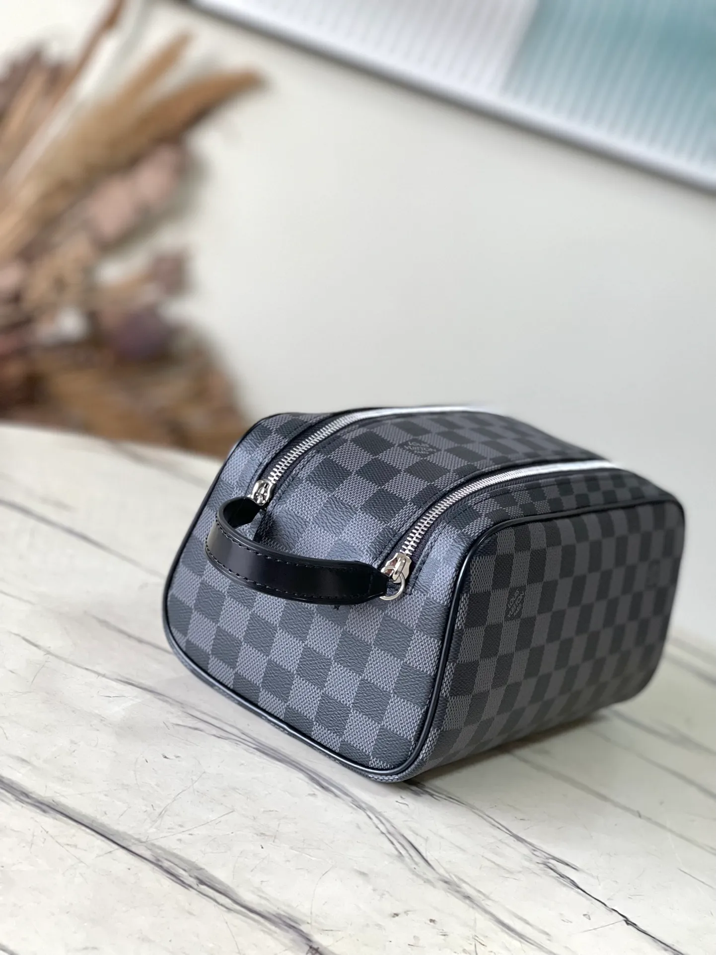 💰660 Top Original N40127 Black Dopp Washing Bag is made of classic Damier Graphite canvas and cow leather trim and has a hard design. Double zippers hide ample internal space for easy access to washing and combing tools. The wide handle makes it comfortable to carry or hang on a bathroom hook. Dimensions: 28 × 15 × 16.5 cm