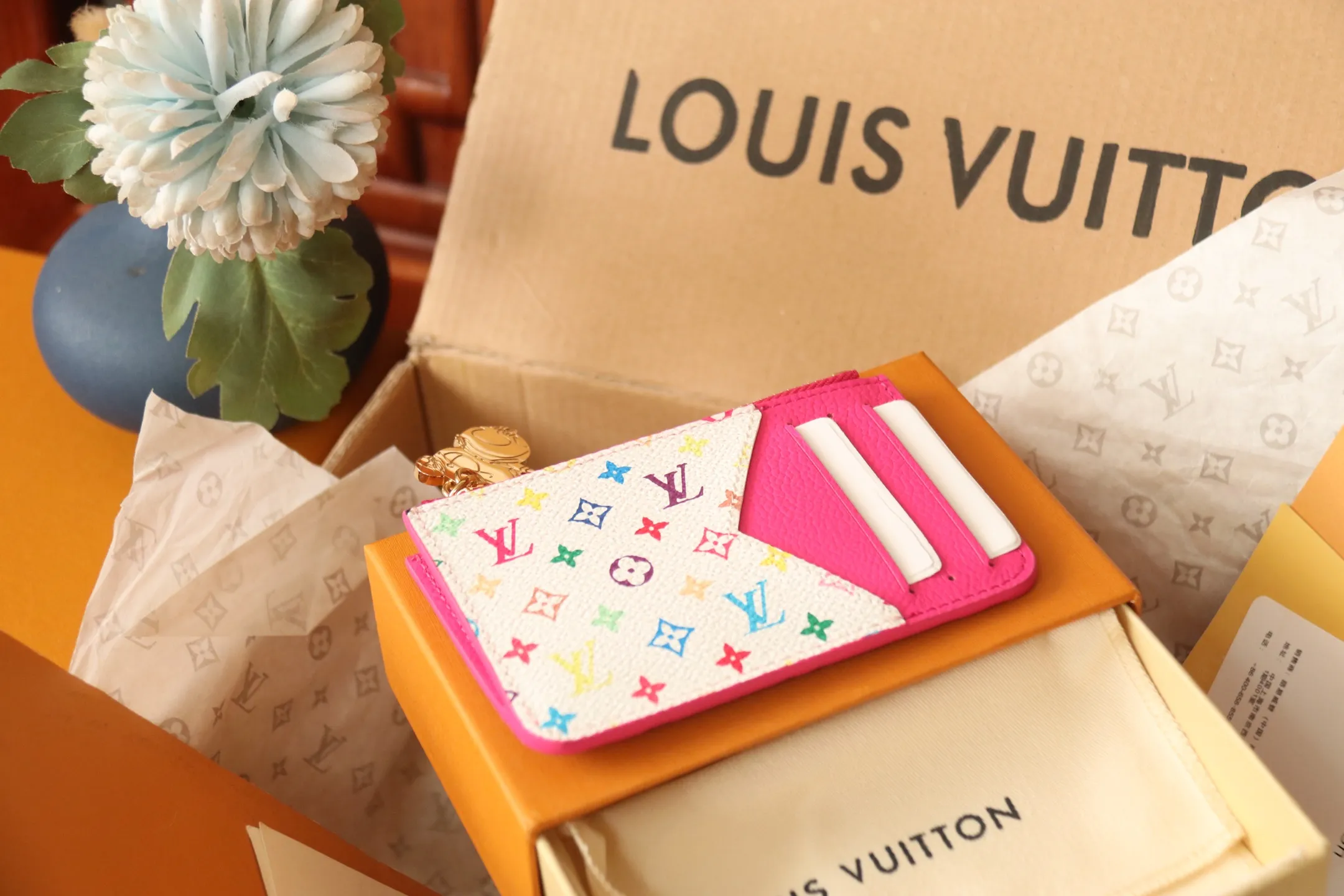 【LV x TM Romy Card Holder】 💎P400 m14155 Rose m14171 Blue m13800 Green "LV × TM Porto Kurt Romy" appears in the "Louis Vuitton × Takashi Murakami" series that unfolds in a variety of categories. It features functional and playful expressions with fresh tones inspired by the rainbow colors unique to Japanese artists. The whole piece is finished with Monogram Amplant leather that adds a casual personality, and the bright Monogram multi-color canvas in the flat pocket stands out. The coin pocket opens and closes with a gold zipper and features a panda pull to symbolize the season.  Dimensions: 12 x 8 x 0.8 cm