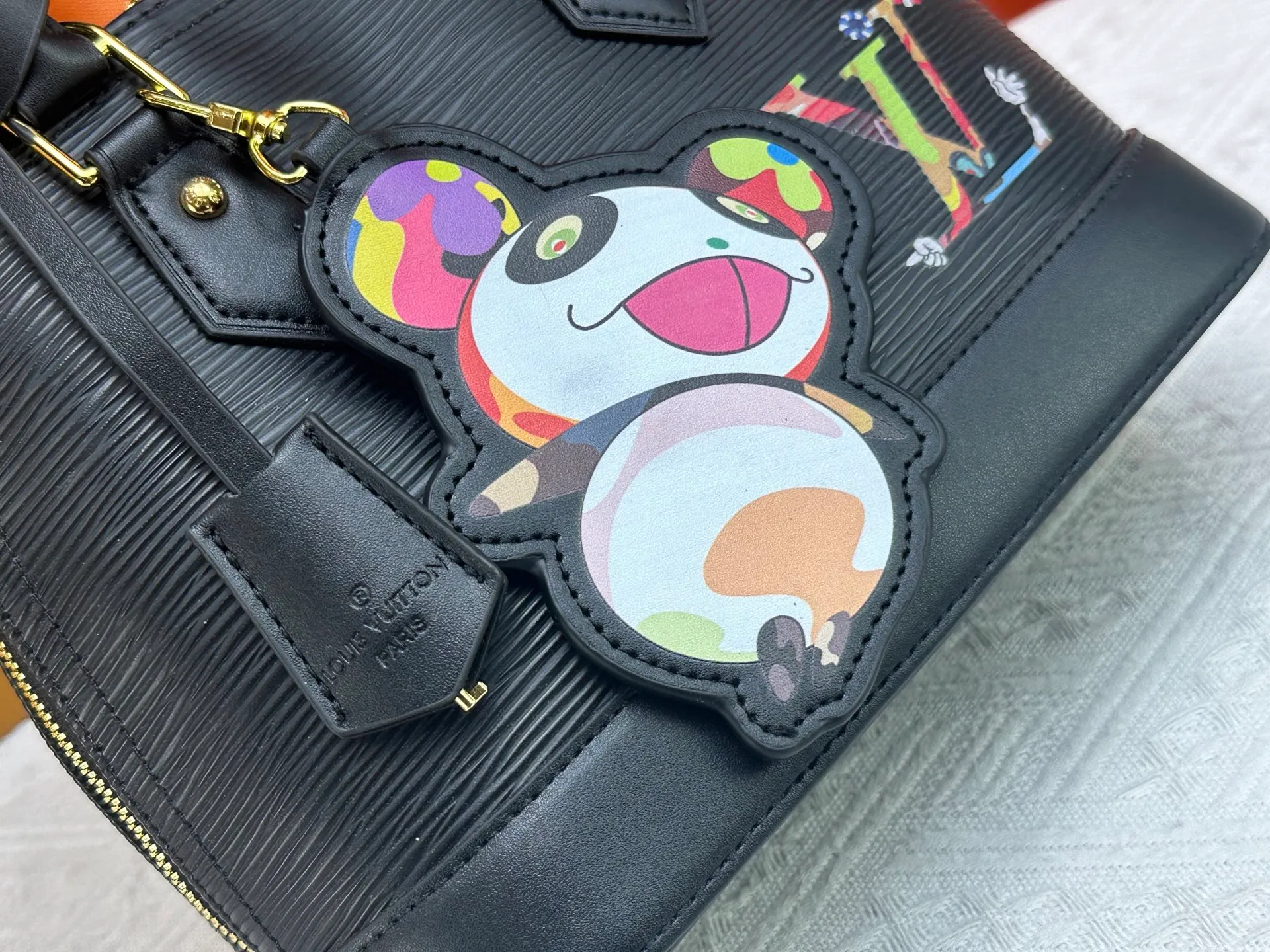 p300 Upgraded original M13670 M14197 M53152 This Alma BB handbag is made of Epi leather and appears in the Louis Vuitton x Murakami reissue series. The smart LV letters on the front reflect the Japanese artist's "ultra-flat" aesthetic, which contrasts with the removable distinctive panda decoration. Top handles, a removable shoulder strap and a dazzling padlock complete the Art Deco design. Dimensions: 23.5 x 17.5 x 11.5 cm (length x height x width)