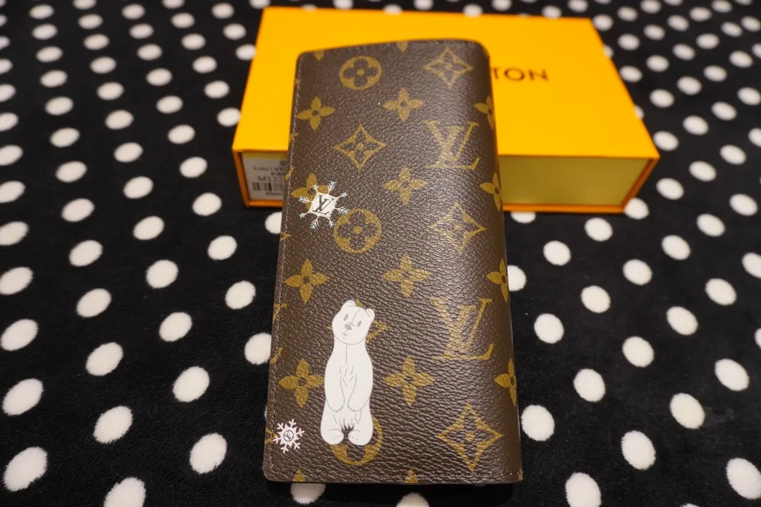 P150 62665, model number 12205 This LV Charms card holder is from the SnowShow series, incorporating smooth leather trim and festive graphics into the iconic Monogram canvas. The brand mascot Vivienne’s pet dog Petula lives in a corner, and Vivienne decorations and LV flowers complete the exquisite design. Dimensions 19x10x2