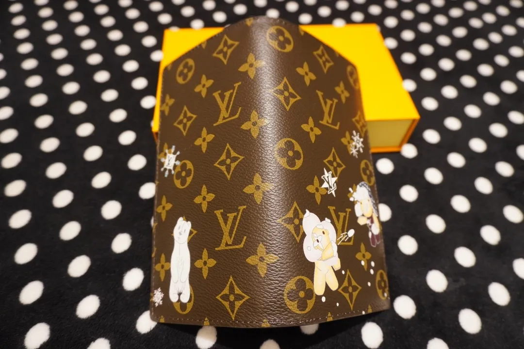 P150 62665, model number 12205 This LV Charms card holder is from the SnowShow series, incorporating smooth leather trim and festive graphics into the iconic Monogram canvas. The brand mascot Vivienne’s pet dog Petula lives in a corner, and Vivienne decorations and LV flowers complete the exquisite design. Dimensions 19x10x2