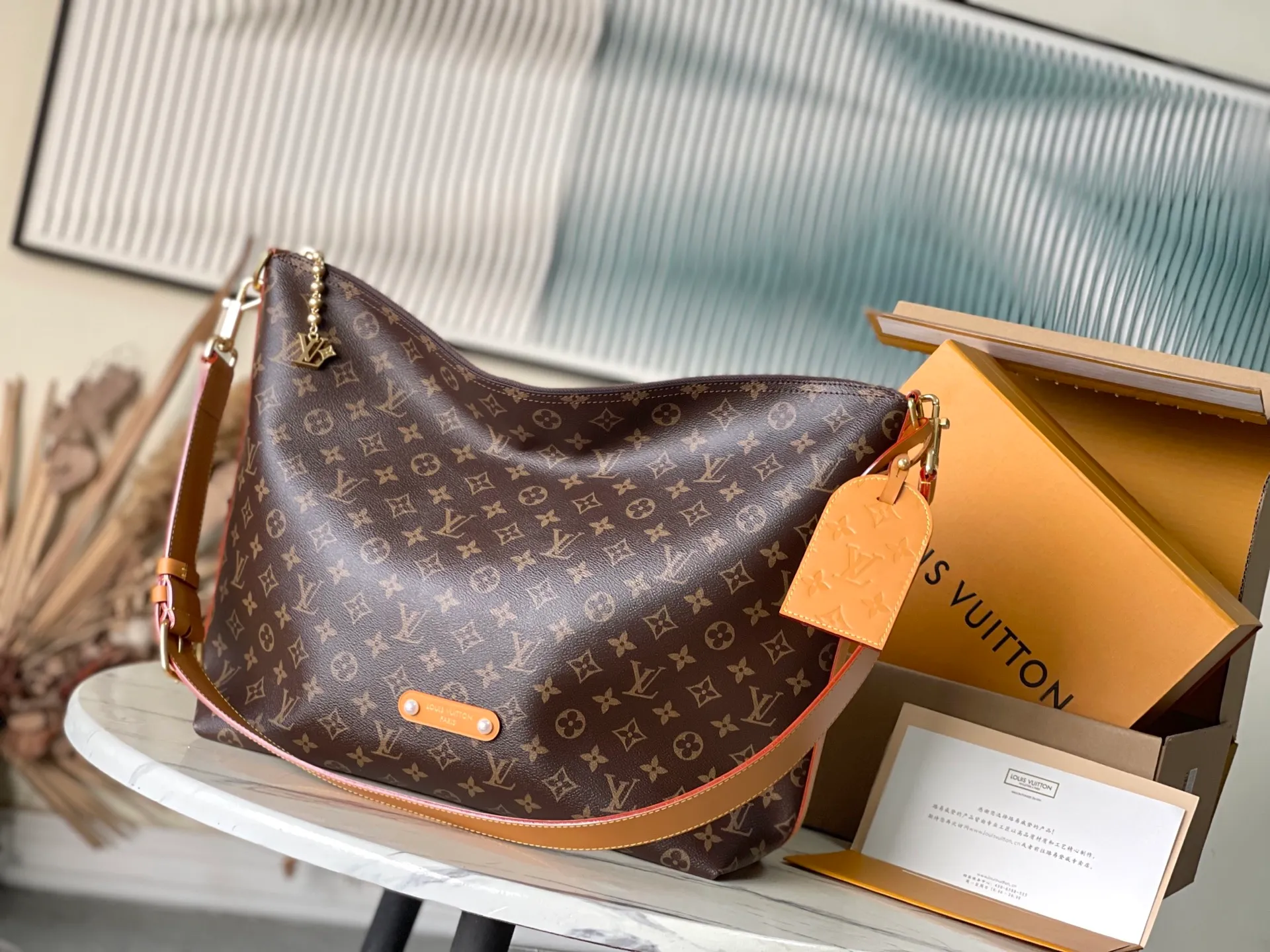 💰1080 Top Original M14018 This Vagabond Hobo handbag is made of soft Monogram canvas, with a crescent-shaped configuration to achieve a modern design that is both comfortable and chic. The distressed leather trim, V letter decoration and bright bead chain all reveal a retro style. Dimensions: 35×12×38 cm