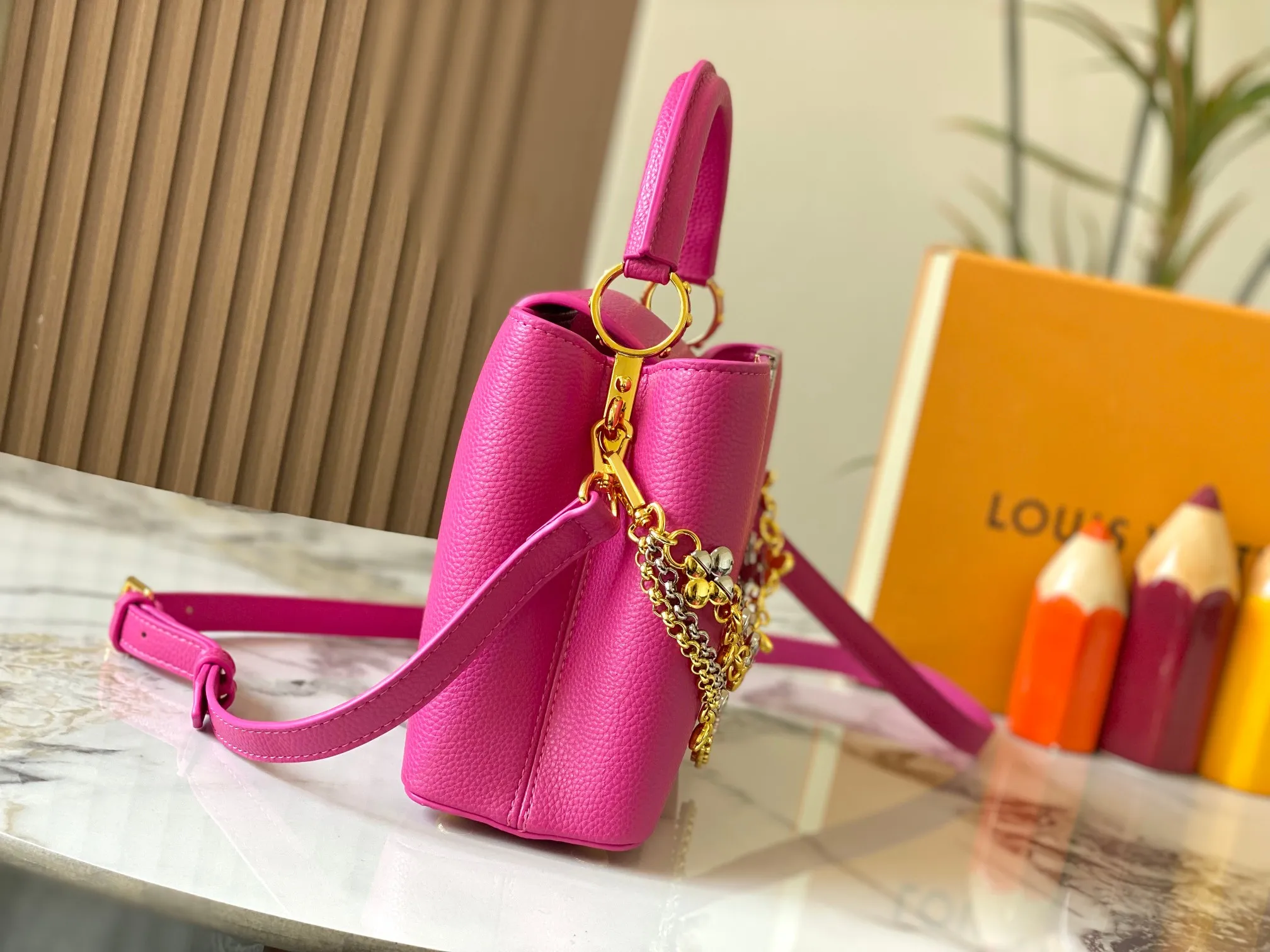 P500 [Guangzhou top quality original version] M26532 Rose Red This modern version of Capucines BB is made of timeless Taurillon leather and equipped with a jewelry-inspired Infinity chain. The bag is decorated with double galvanized metal parts, including the iconic Monogram floral pattern, and the LV Initials logo created with sunburst technology, creating a sundial-like light and shadow effect. The bag has multiple pockets and a detachable shoulder strap, allowing it to be carried on one shoulder or across the body. 27 x 17.3 x 9 (cm) (length x height x width)