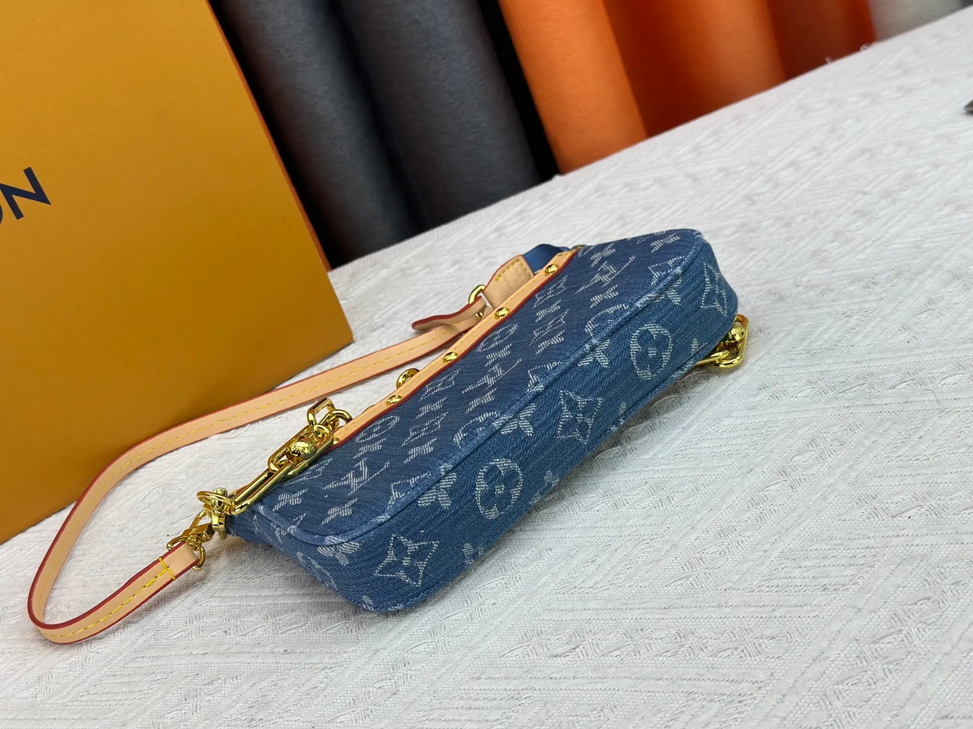 P230 M13404 Denim Denim This Pochette Accessoires handbag is made of coated canvas and uses colorful Monogram patterns to interpret the smart style of the Louis Vuitton x Murakami cross-border collaboration series. Calf leather trim and dazzling hardware add to the sophisticated details, while the detachable shoulder strap and chain provide flexible carry. Size: 22x13x4cm