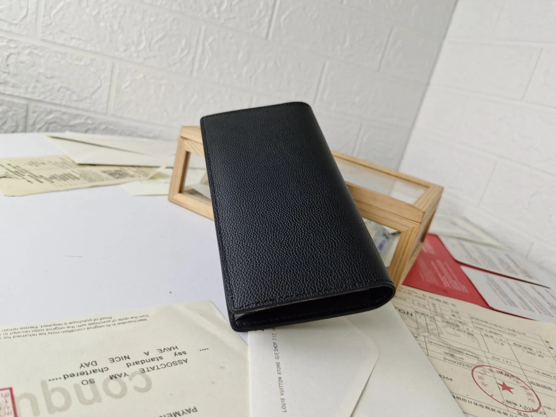 P140💰Top original version💎【Real shot with home background】M58192 black pebbled suit clip Elegant is the best way to describe Brazza, a wallet that is both flexible, easy to use and elegant, and can be easily stored in the chest pocket. Crafted from extremely soft yet durable Taurillon leather, this wallet is even more attractive. Details 10 x 19 x 2 cm (Length x Height x Width) Cowhide embellished wallet Front embossed Louis Vuitton initials Palladium finish Brass hardware Cowhide lining 12 credit card slots, 1 slot for ID or business cards 1 large zipped coin compartment 4 internal slip pockets for banknotes, IDs, receipts 62665