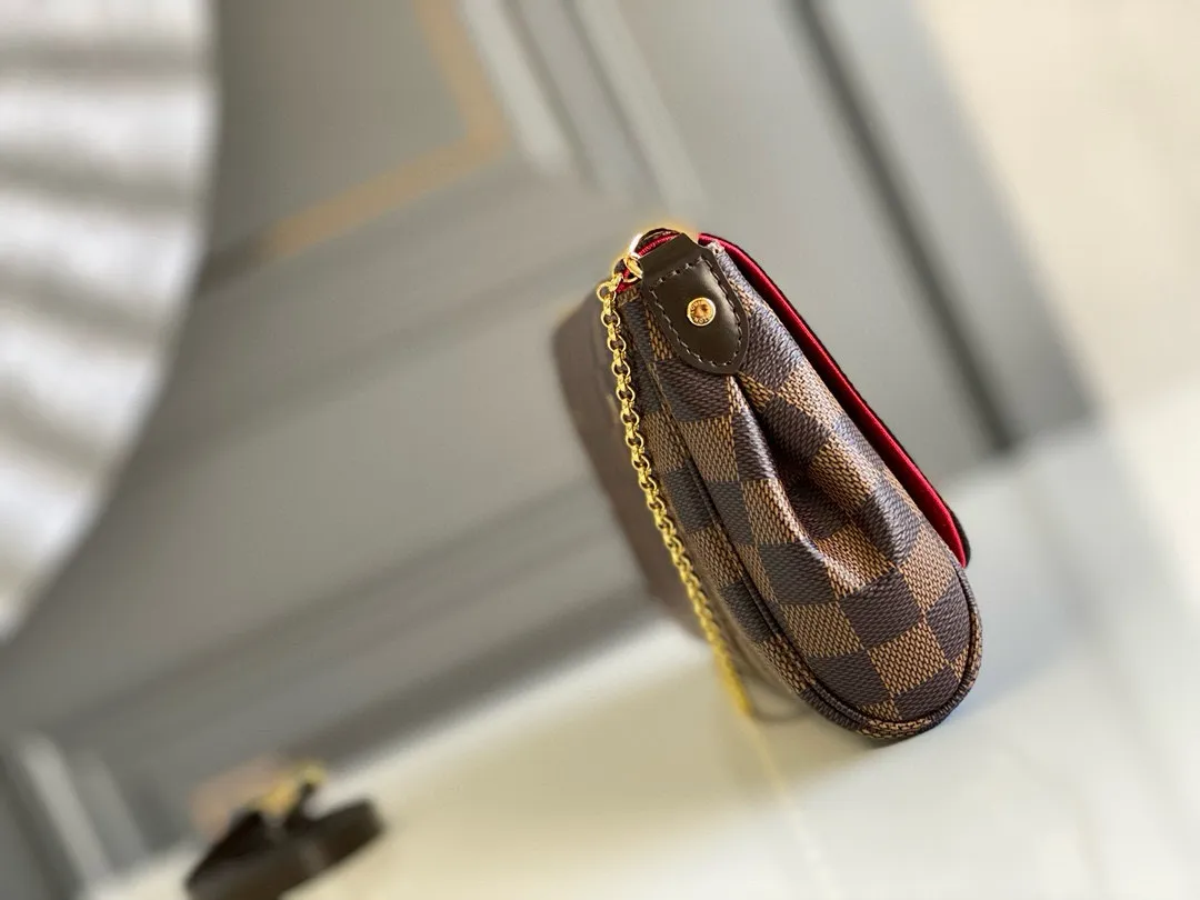 💰640 Top original item N41129 FAVORITE MM This Favorite MM handbag is the darling of fashionable women. It is sewn with geometric-style Damier Ebene canvas and is suitable for morning and evening occasions. The bag can be used as a clutch, or can be carried as a short shoulder bag using the gold chain strap, while the leather shoulder strap can be easily carried cross-body. An engraved metal plaque on the front conceals a clever magnetic closure for safe access. Details 26 x 15 x 4 cm (Length x Height x Width) Damier Ebene coated canvas Natural cowhide leather trim Textile lining Gold-tone hardware Magnetic flap closure Internal patch pocket Shoulder strap: Non-detachable, not adjustable Strap vertical height: 52.0 cm Chain strap: Detachable Chain strap vertical height: 17.0 cm