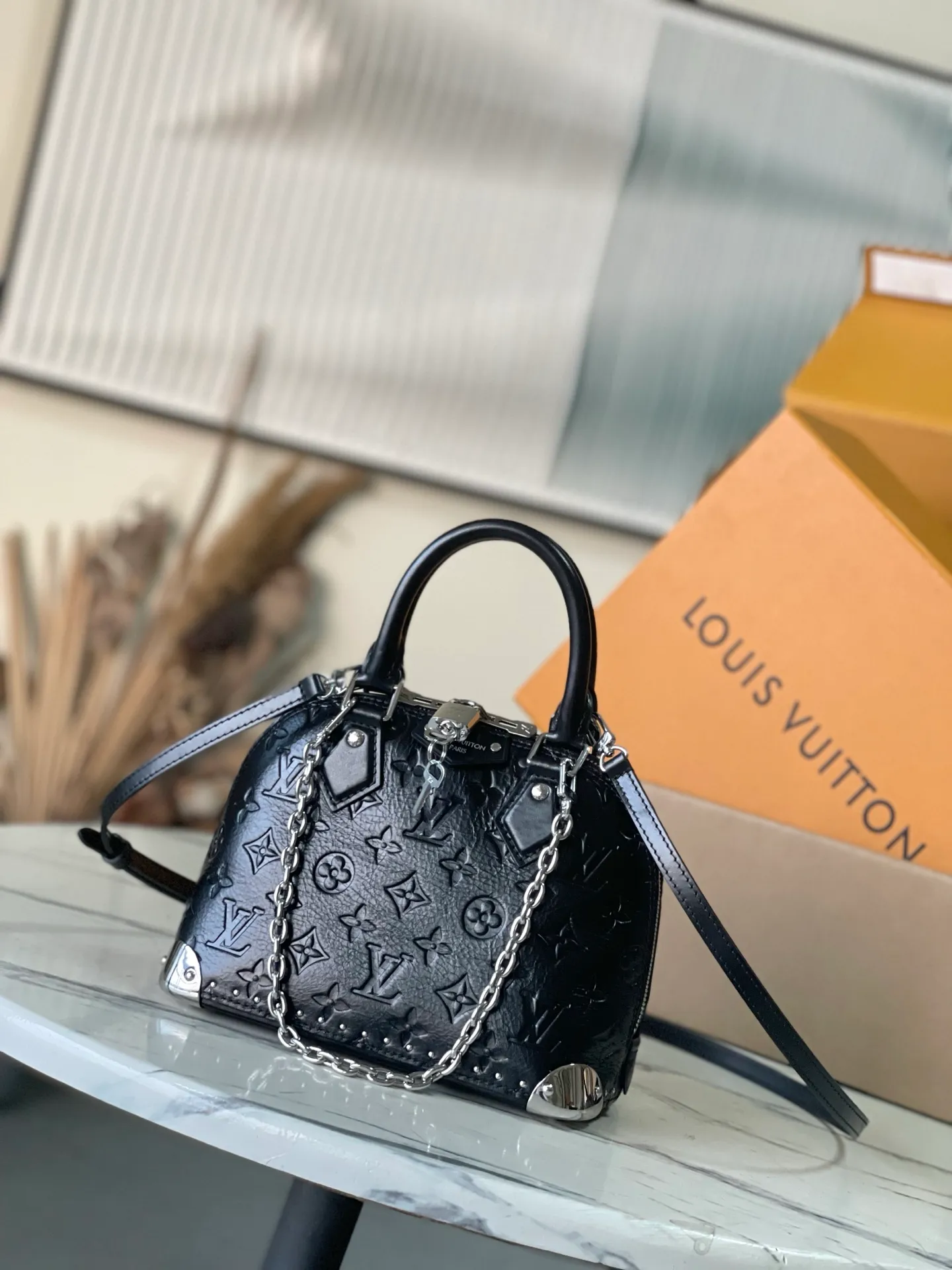 💰1220 (top layer leather) top original order M27812 This Alma BB handbag displays the brand’s Monogram Saga logo, exuding a retro atmosphere and rock style. It's made from cow leather and trimmed with cow leather, and features a chunky chain and signature S-lock that complements the metal corners. There are a variety of carrying methods, and the internal space can accommodate daily needs. Dimensions: 22 × 19 × 11 cm