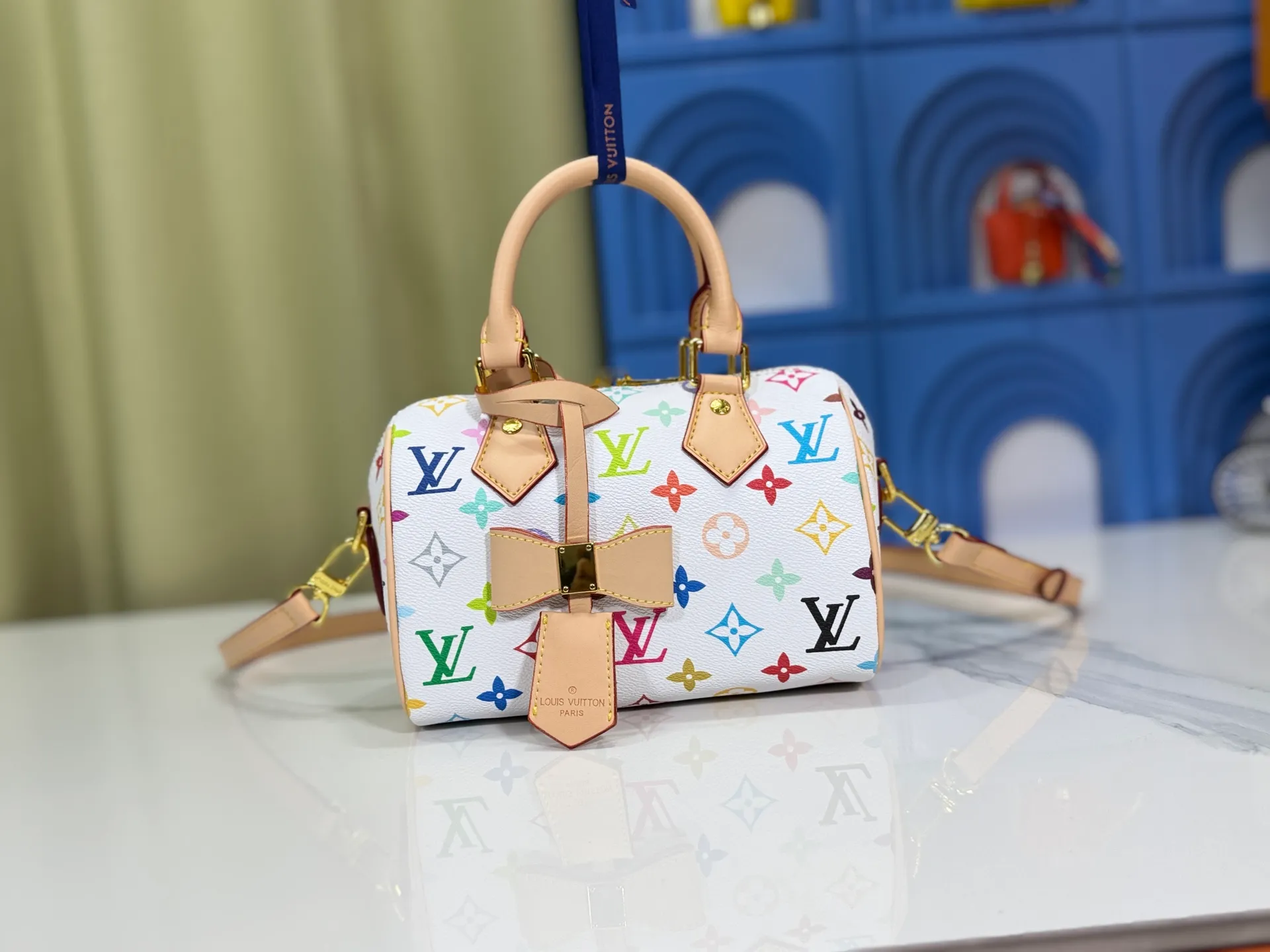 P260 Upgraded from the original version, this M46234 M46222 Speedy Bandoulière 20 handbag is made of soft coated canvas, with the full-length Monogram pattern traced in colorful rainbow tones, highlighting the smart style of the Louis Vuitton x Murakami reissue series. The Toron handle and detachable shoulder strap are constructed of cow leather, the metal corners recall classic luggage elements, and the bow-shaped key bag and padlock add brand touches. Dimensions: 20.5 x 13.5 x 12.0 cm (length x height x width)