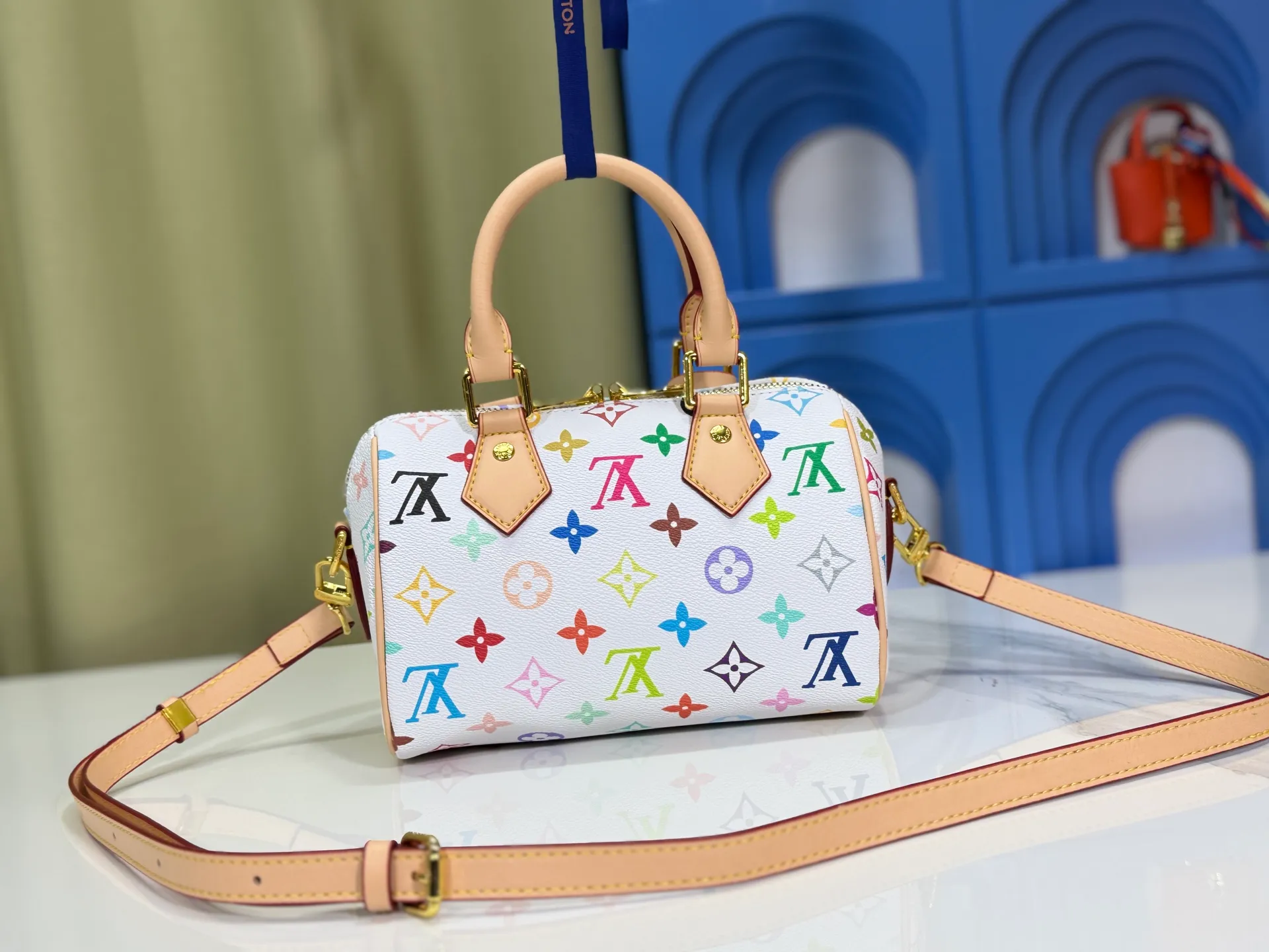 P260 Upgraded from the original version, this M46234 M46222 Speedy Bandoulière 20 handbag is made of soft coated canvas, with the full-length Monogram pattern traced in colorful rainbow tones, highlighting the smart style of the Louis Vuitton x Murakami reissue series. The Toron handle and detachable shoulder strap are constructed of cow leather, the metal corners recall classic luggage elements, and the bow-shaped key bag and padlock add brand touches. Dimensions: 20.5 x 13.5 x 12.0 cm (length x height x width)