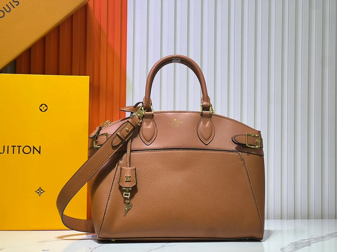 Batch 340💰M11214 green M22914 black M22925 brown M23061 off-white M22927 taupe. Sophisticated and functional, the Lock It MM bag is crafted in fine grained Taurillon leather and smooth calfskin, with gold-finish buckles and hardware. Signature House touches include padlocks, key bells and hot-stamped Louis Vuitton signatures. Featuring an articulated top handle and removable strap, this tote offers a variety of carrying options. 36x29x15 cm (LxHxW) Black Taurillon leather, smooth calfskin semi-leather trim Microfiber lining Gold hardware 2 square buckles padlock key bell External pockets 2 internal flat pockets Internal zipped pocket with flat pockets 5 protective metal studs Strap: removable, adjustable Strap drop: 45.0 cm Maximum strap drop: 51.0 cm