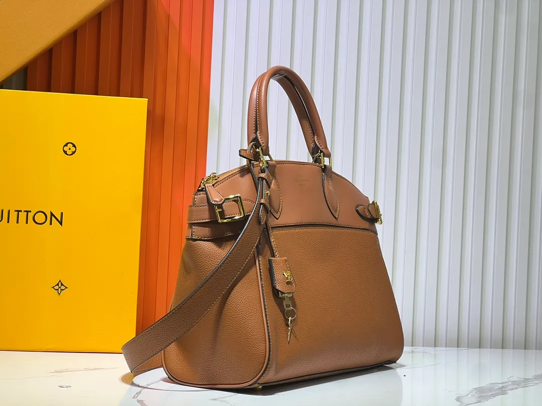 Batch 340💰M11214 green M22914 black M22925 brown M23061 off-white M22927 taupe. Sophisticated and functional, the Lock It MM bag is crafted in fine grained Taurillon leather and smooth calfskin, with gold-finish buckles and hardware. Signature House touches include padlocks, key bells and hot-stamped Louis Vuitton signatures. Featuring an articulated top handle and removable strap, this tote offers a variety of carrying options. 36x29x15 cm (LxHxW) Black Taurillon leather, smooth calfskin semi-leather trim Microfiber lining Gold hardware 2 square buckles padlock key bell External pockets 2 internal flat pockets Internal zipped pocket with flat pockets 5 protective metal studs Strap: removable, adjustable Strap drop: 45.0 cm Maximum strap drop: 51.0 cm
