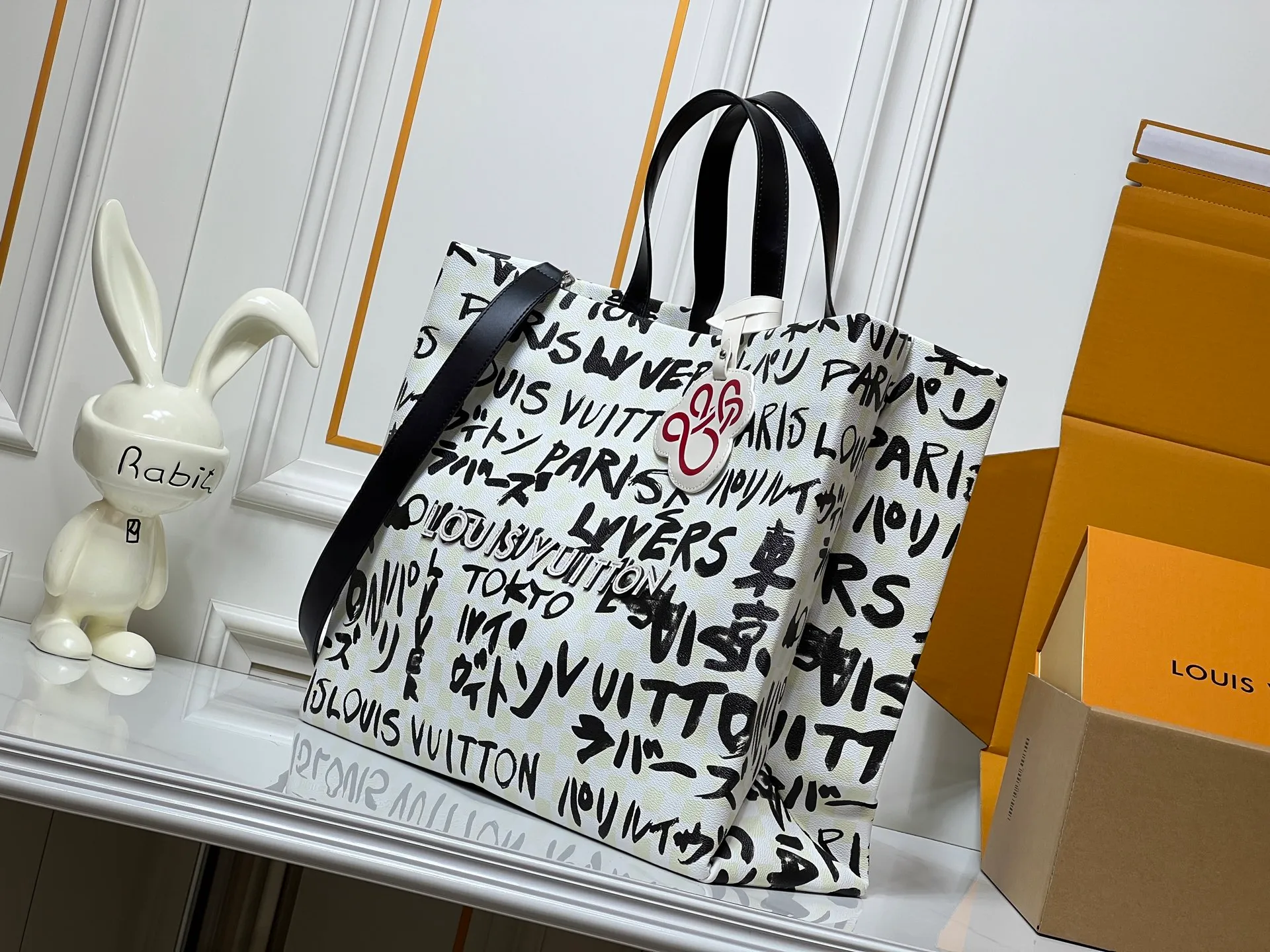 Batch 320💰M24457 M40797 This Shopper Tote medium handbag features Damier checkerboard pattern superimposed with eye-catching hand-painted elements, witnessing the joint creativity of Pharrell Williams and Japanese designer Nigo. The names Louis Vuitton, Paris and Tokyo, as well as the word Lvvers, are bilingual in French and Japanese, and the graphic cotton lining showcases Nigo's signature style. Size: 41x34x16cm
