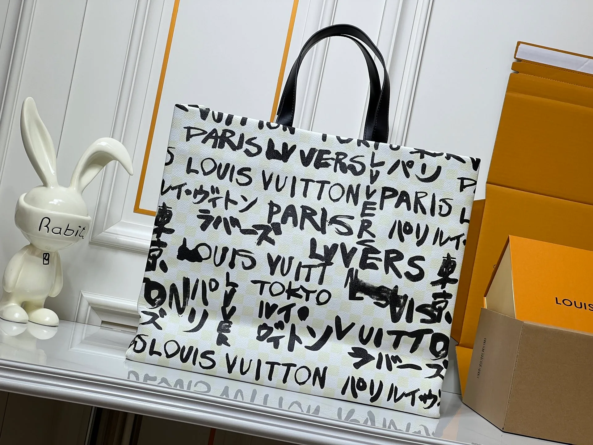 Batch 320💰M24457 M40797 This Shopper Tote medium handbag features Damier checkerboard pattern superimposed with eye-catching hand-painted elements, witnessing the joint creativity of Pharrell Williams and Japanese designer Nigo. The names Louis Vuitton, Paris and Tokyo, as well as the word Lvvers, are bilingual in French and Japanese, and the graphic cotton lining showcases Nigo's signature style. Size: 41x34x16cm
