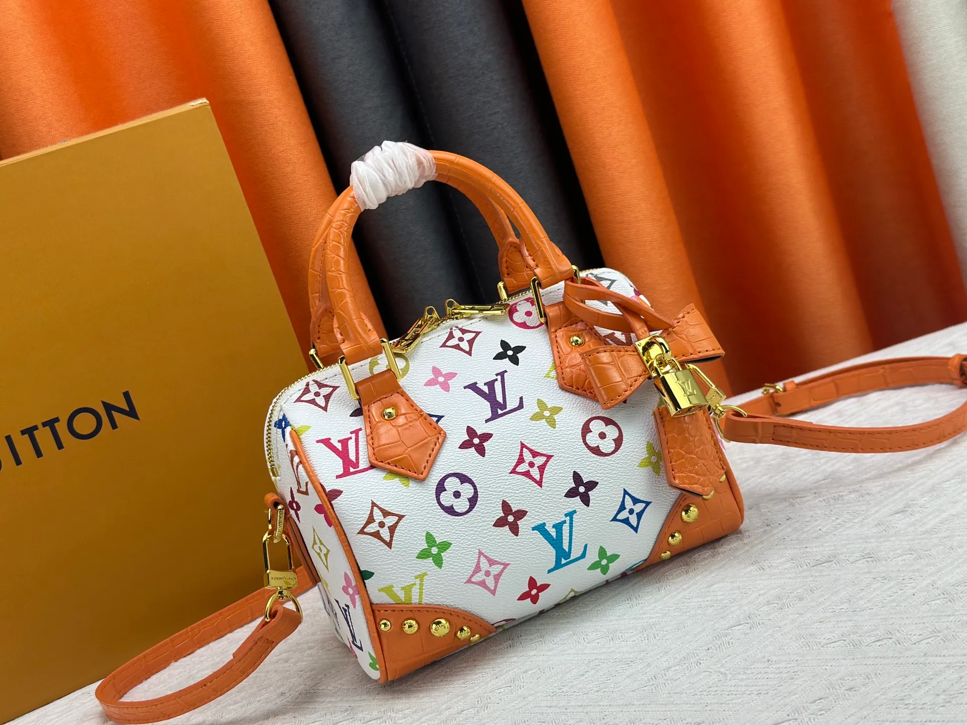 P260 Upgraded original crocodile pattern M13365 M58953 M46234 M46222 Speedy Bandoulière 20 handbag is made of soft coated canvas, and the full-length Monogram pattern is traced in colorful rainbow tones, highlighting the smart style of the Louis Vuitton x Murakami reissue series. The Toron handle and detachable shoulder strap are constructed of cow leather, the metal corners recall classic luggage elements, and the bow-shaped key bag and padlock add brand touches. Dimensions: 20.5 x 13.5 x 12.0 cm (length x height x width)
