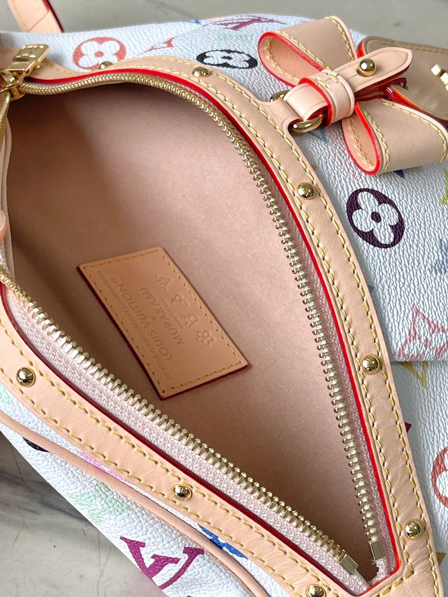 💰900 Top Original M13660 The High Rise bumbag is an iconic piece in the vibrant prints of the reissued Louis Vuitton x Murakami collection: crafted in coated canvas, the signature Monogram pattern is rendered in a rainbow of colors, referencing the Japanese artist’s signature palette of pop colors. The brand's signature natural cowhide leather highlights the front zipper and arched LV x TM name tag. Dimensions: 34.5×16×7,5cm (length x height x width)
