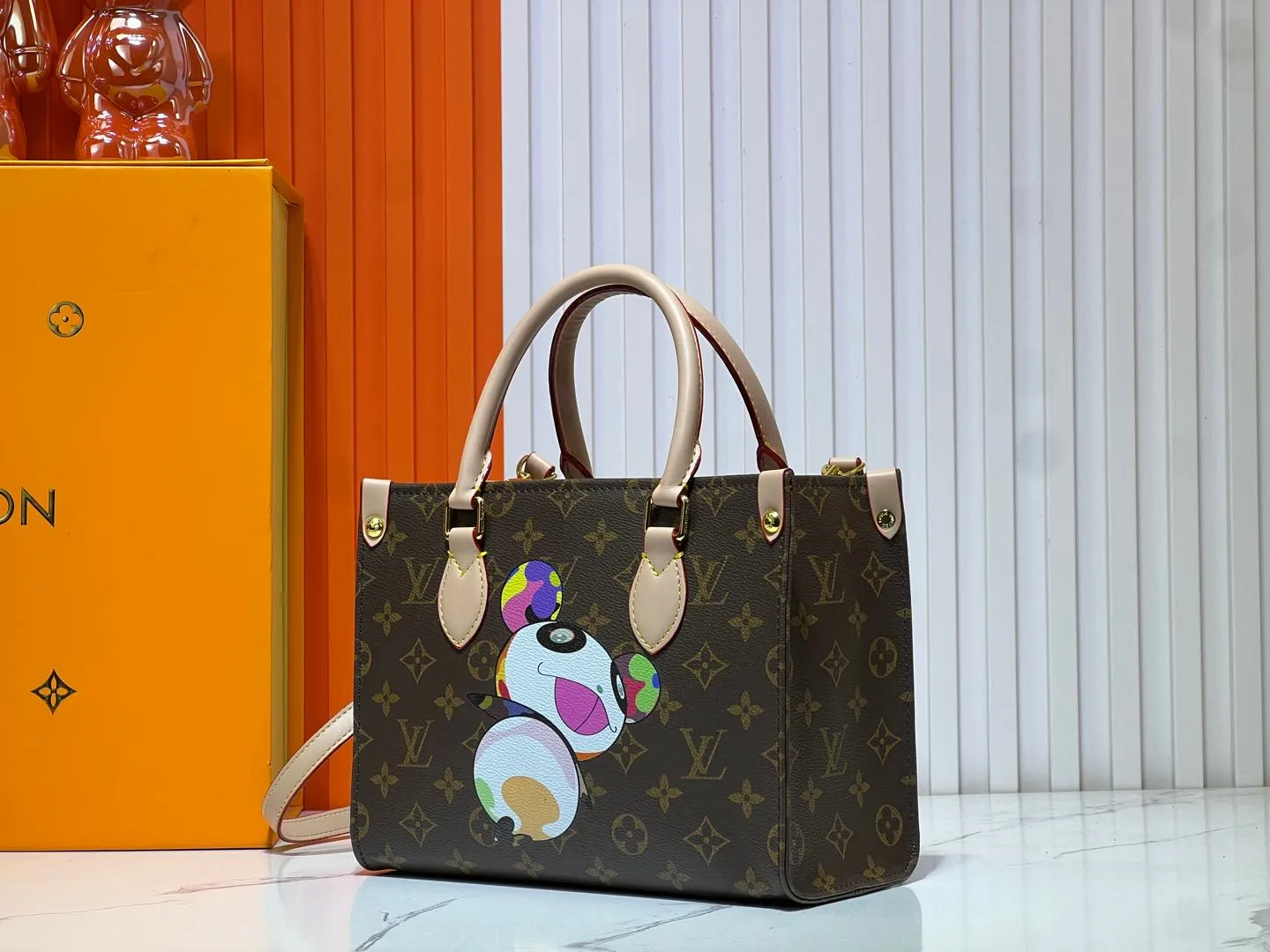 Batch 280💰M45659 M13668!🔥Lv&Takashi Murakami🐼Panda print OnTheGo small new version The legendary ONTHEGO handbag: always able to meet your various needs for handbags. It has a large capacity but is not bulky. It is stiff and soft to the touch, making it suitable for home and travel. Tighten the side ties and it instantly transforms into a stylish urban handbag. Loosen the straps and it transforms into a chic and practical handbag. The slender leather handle can be carried over the shoulder or between the arms. The model shown here is made of Damier Azur canvas. Size: 25x11x19cm