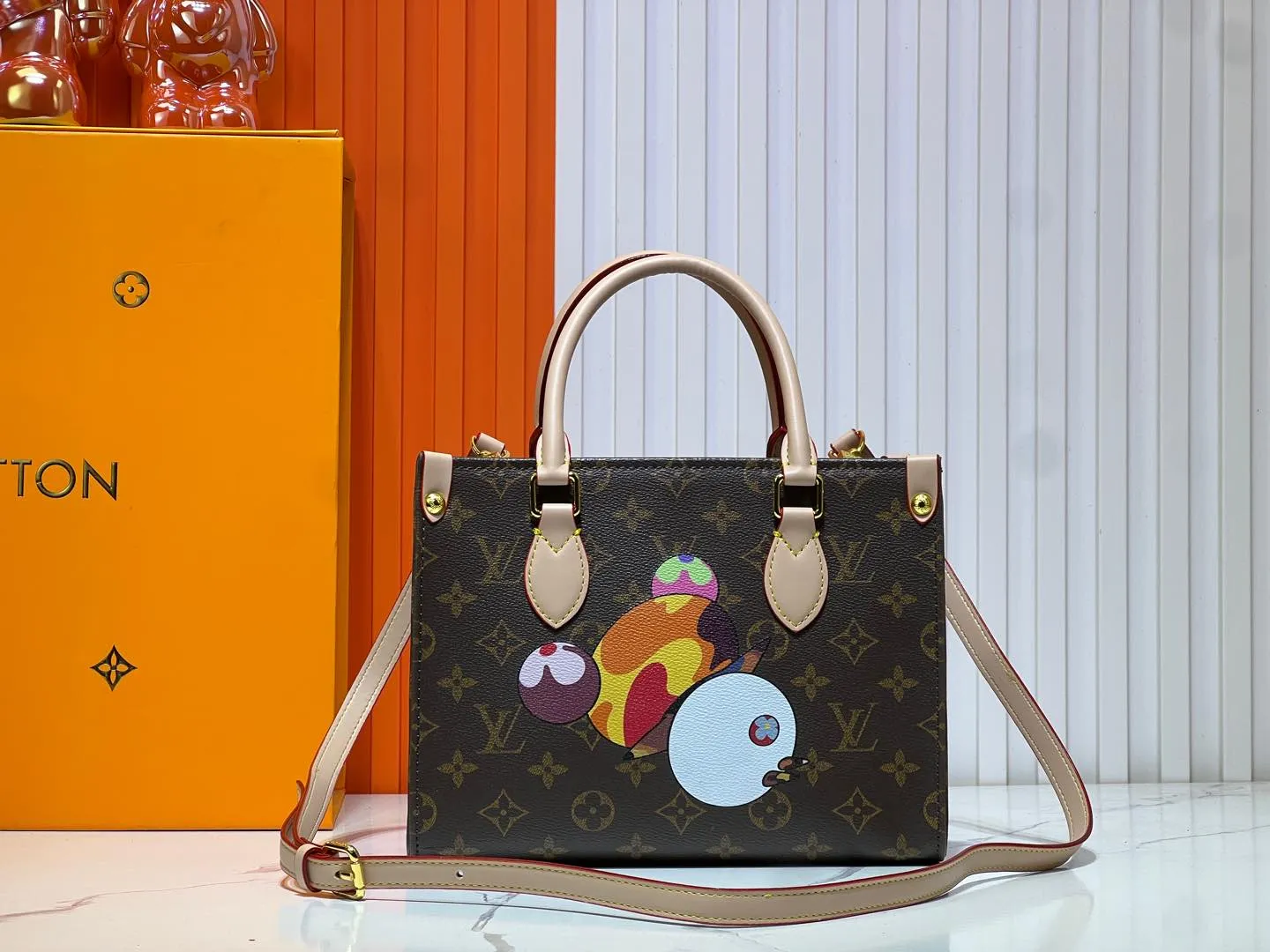 Batch 280💰M45659 M13668!🔥Lv&Takashi Murakami🐼Panda print OnTheGo small new version The legendary ONTHEGO handbag: always able to meet your various needs for handbags. It has a large capacity but is not bulky. It is stiff and soft to the touch, making it suitable for home and travel. Tighten the side ties and it instantly transforms into a stylish urban handbag. Loosen the straps and it transforms into a chic and practical handbag. The slender leather handle can be carried over the shoulder or between the arms. The model shown here is made of Damier Azur canvas. Size: 25x11x19cm