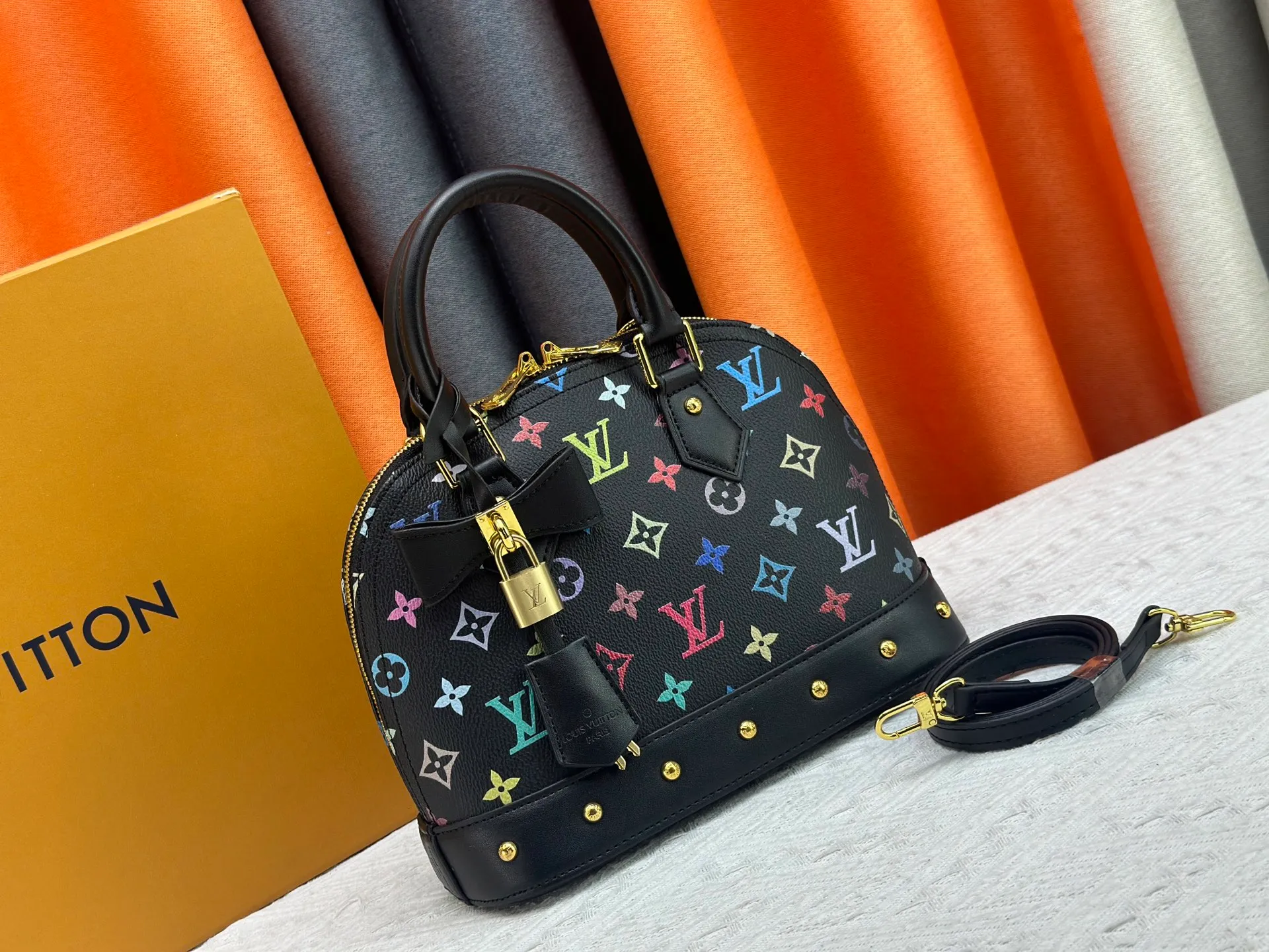 P300 Upgraded original M13078 M53152 This Alma BB handbag exudes the cheerful style of the Louis Vuitton x Murakami collaboration series, cleverly recalling the Art Deco design of the 1930s. Monogram coated canvas renders Murakami's playful tones, while classic calfskin touches the Toron handle, base, detachable shoulder strap and LV x TM key holder. 17.5 x 11.5 x 23.5 cm (height x width x length)