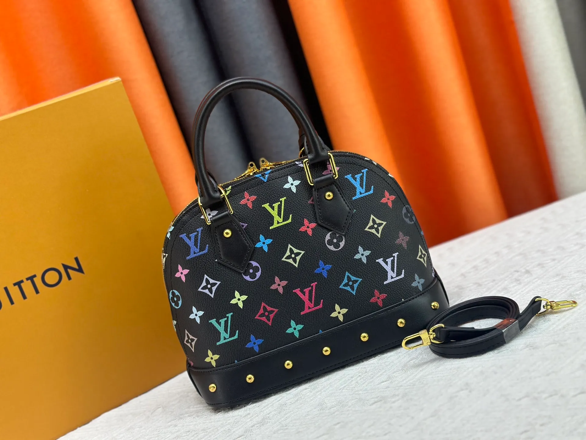 P300 Upgraded original M13078 M53152 This Alma BB handbag exudes the cheerful style of the Louis Vuitton x Murakami collaboration series, cleverly recalling the Art Deco design of the 1930s. Monogram coated canvas renders Murakami's playful tones, while classic calfskin touches the Toron handle, base, detachable shoulder strap and LV x TM key holder. 17.5 x 11.5 x 23.5 cm (height x width x length)