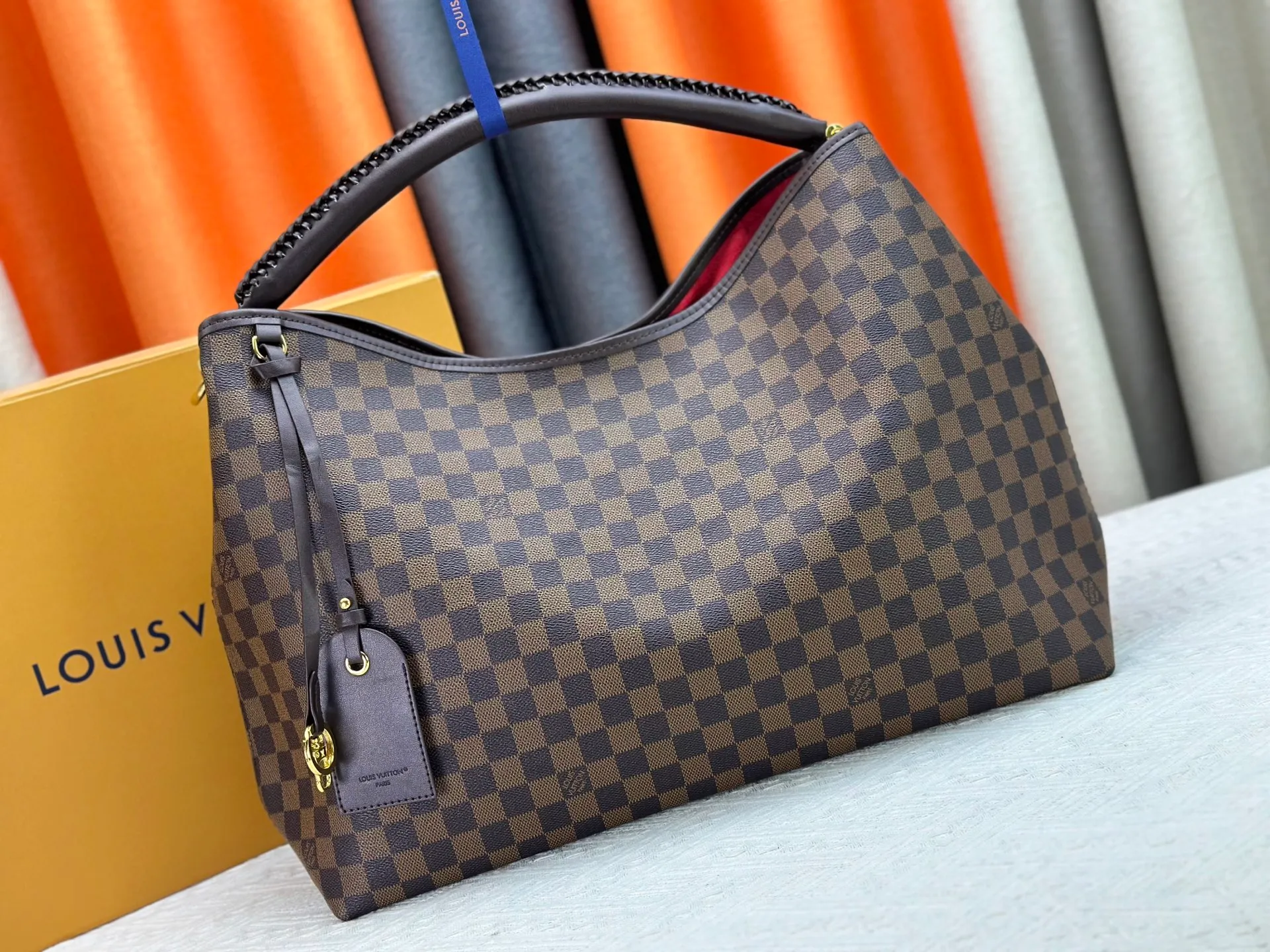 P300 upgrades the original M25877 Again bag, a new interpretation of the iconic Artsy design first launched in 2010, now more flexible, more iconic and more refined. Rooted in LV’s DNA, this bag pays homage to Louis Vuitton’s craftsmanship with its classic Monogram canvas base, hand-woven handles and customizable name tag. It's spacious enough to hold a laptop and opens to reveal multiple pockets. Gold hooks can be used to hang playful accessories! ! Size:50x30x15.5CM