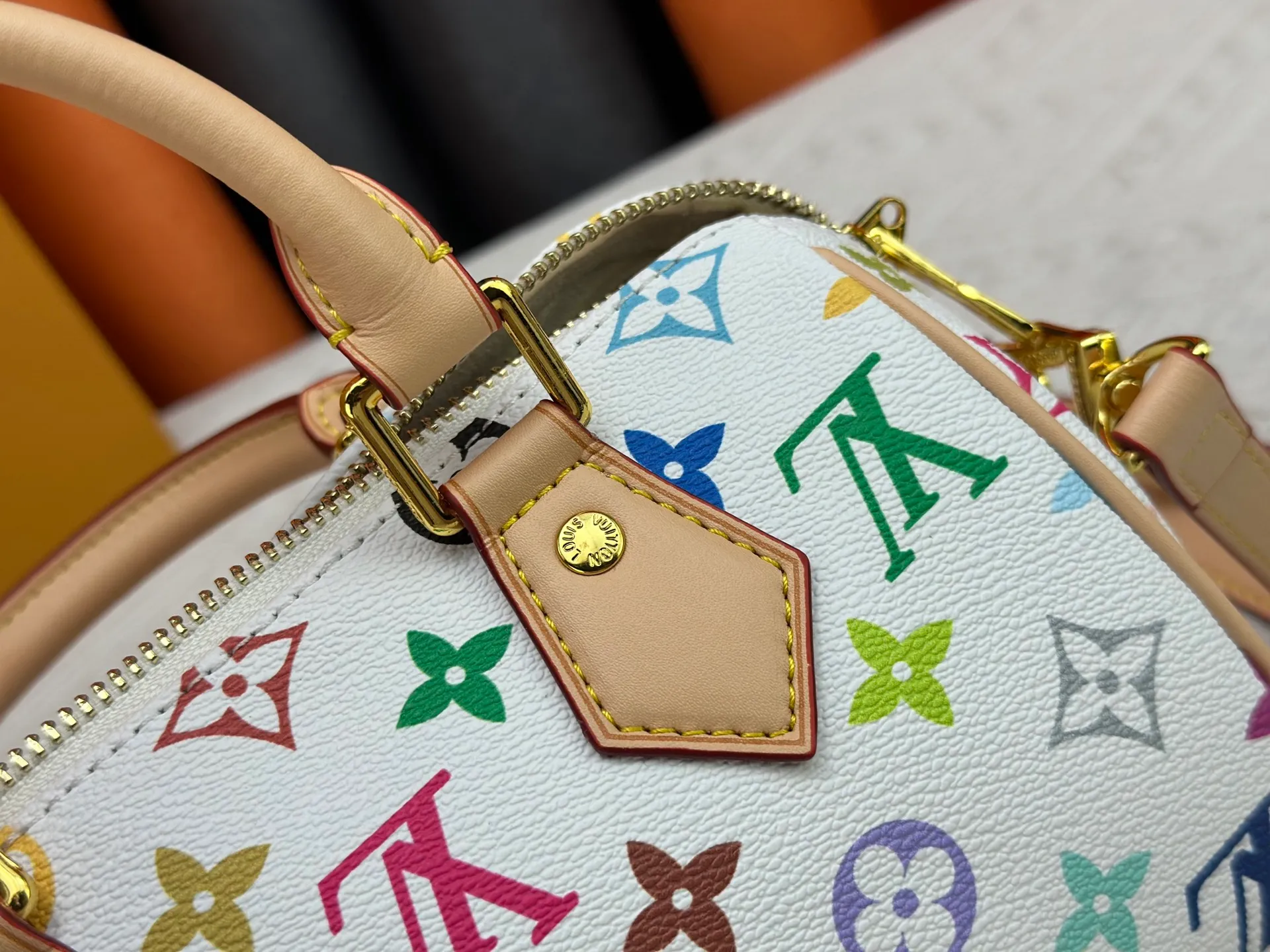 P260 Upgraded from the original version, this M46234 M46222 Speedy Bandoulière 20 handbag is made of soft coated canvas, with the full-length Monogram pattern traced in colorful rainbow tones, highlighting the smart style of the Louis Vuitton x Murakami reissue series. The Toron handle and detachable shoulder strap are constructed of cow leather, the metal corners recall classic luggage elements, and the bow-shaped key bag and padlock add brand touches. Dimensions: 20.5 x 13.5 x 12.0 cm (length x height x width)