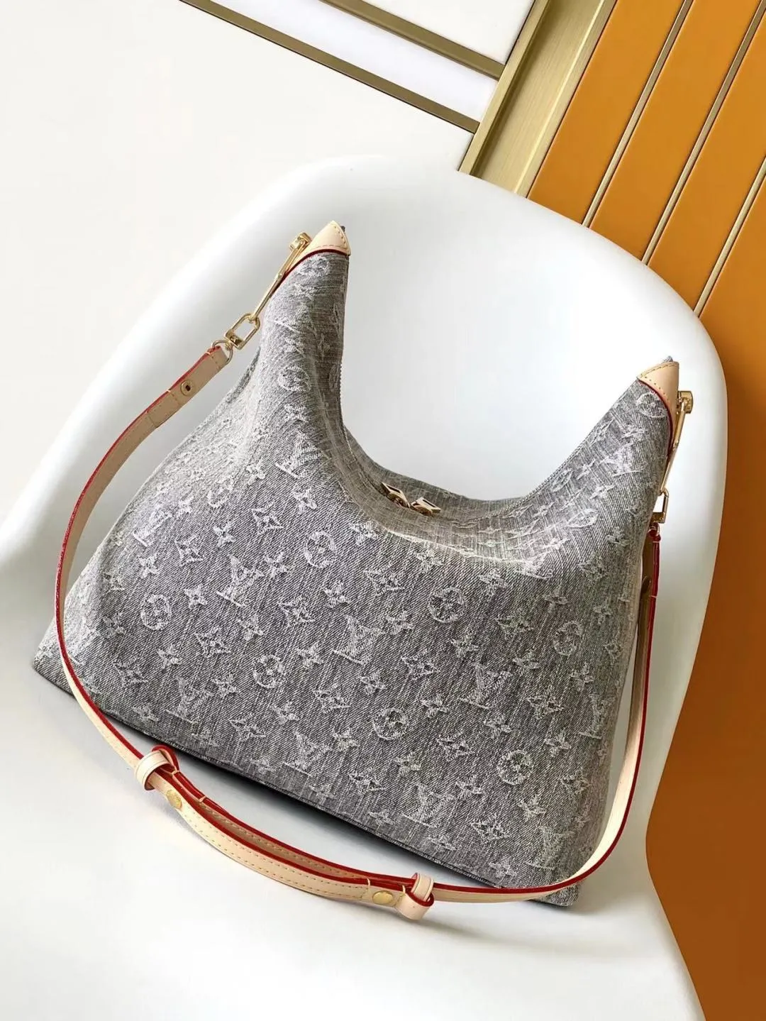 💰1340 Top Original Order M13390 Top Original Order Dynamic 163 This Coussin Hobo MM handbag celebrates the return of the brand’s iconic Monogram Denim pattern, originally launched in 2005. Made of organic cotton, it's woven from black and white yarns that have been faded to create a vintage look. Spacious, it's decorated with a light gold metallic finish and includes a removable pocket with a slide lock to securely store small items. This model can be worn crosswise, on the shoulder or on the hand.  38 x 33 x 10 cm (Length x Height x Width) Gray faded Organic cotton Natural cowhide leather lining Organic cotton lining Light gold-tone metal Sliding door closure Removable inner pocket with zipper Can contain: 13" tablet, smartphone, keys, Zippy wallet, red lips, headphones, other effects Shoulder strap: removable, adjustable Strap length: 30.0 cm Maximum strap length: 50.0 cm Chain: Removable Chain length: 30.0 cm Maximum chain length: 50.0 cm