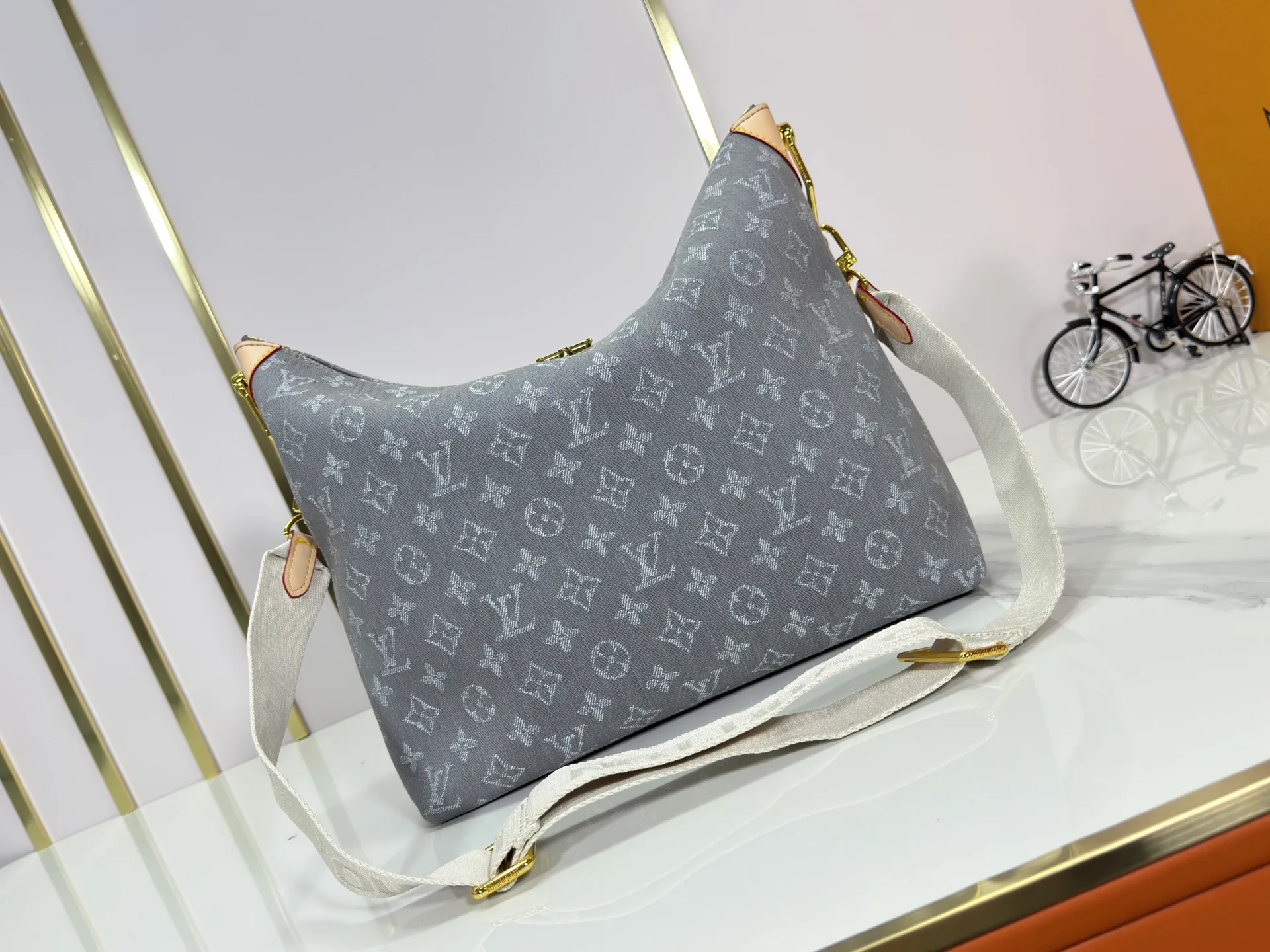 P260 Upgraded Original M13390 M12072 M12068 M12071 This Coussin Hobo MM handbag celebrates the return of the brand's iconic Monogram Denim pattern, originally launched in 2005. Made of organic cotton, it's woven from black and white yarns that have been faded to create a vintage look. Spacious, it's decorated with a light gold metallic finish and includes a removable pocket with a slide lock to securely store small items. This model can be worn crosswise, on the shoulder or on the hand. Dimensions: 38 x 33 x 10 cm