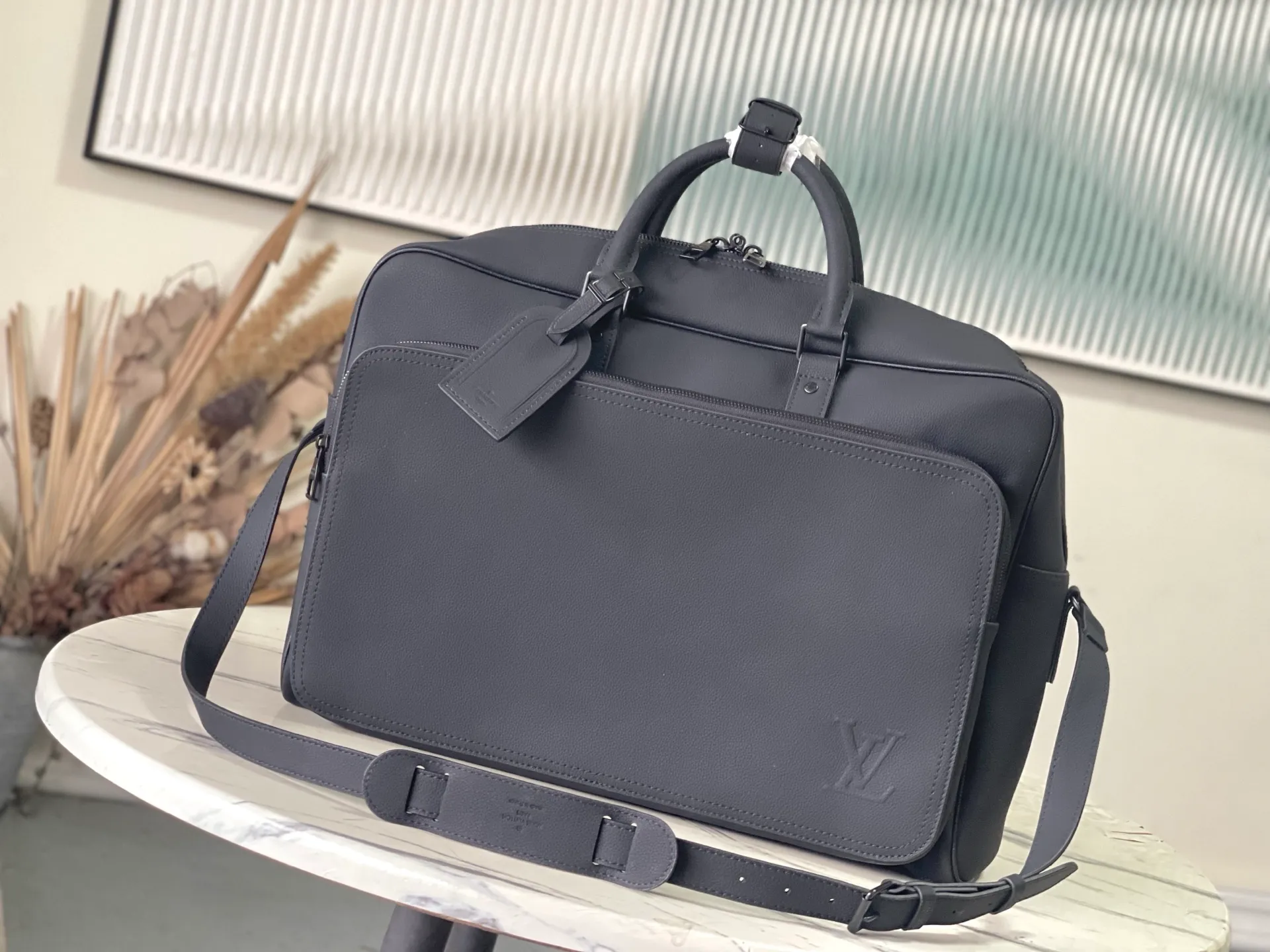 💰1680 (first-grain leather) Top-quality original order M26075 This Weekender Bag handbag is made of waxed cow leather, lining of the same color and bright metal parts. Its size is just right to be placed on the top of the Horizon trolley suitcase, making business travel easy and comfortable. A roomy zippered front pocket expands the main compartment, while a top handle and removable and adjustable shoulder strap provide multiple carrying options. Dimensions: 46 × 31 × 8 cm