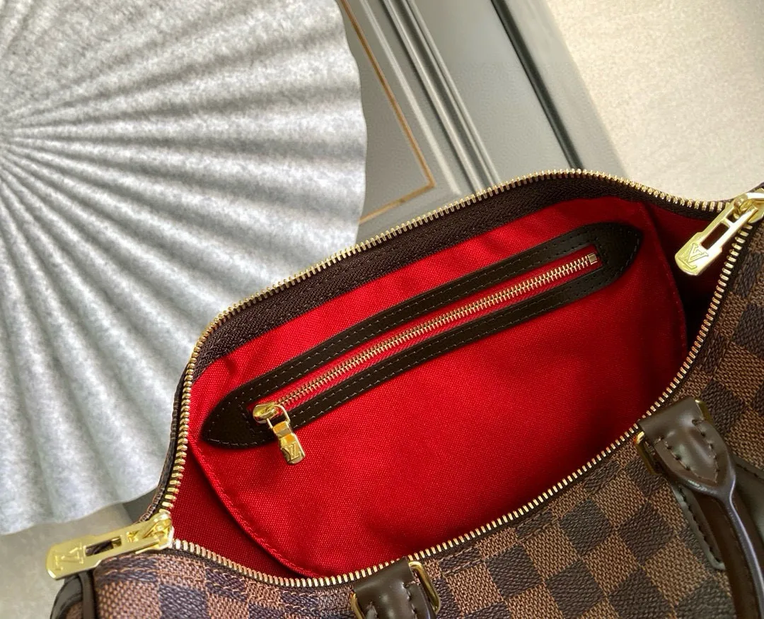 💰840 (size 35) Top original N41366 SPEEDY 35 handbag (with shoulder strap) The Speedy 35 handbag made of Damier Ebène canvas has a classic shape and exudes timeless elegance. The multifunctional shoulder strap can be used to carry it by hand, on the shoulder or across the body, making it flexible and convenient. Detailed features 35 x 23 x 18 cm (Length x Height x Width) Smooth leather trim Shiny gold-tone brass hardware Double zip closure with padlock Internal pocket D-ring for keys and accessories Soft fabric lining Shoulder strap: Removable, adjustable Half-length strap: 47.0 cm Half-length strap adjustable to: 53.5 cm Handle: Double handle