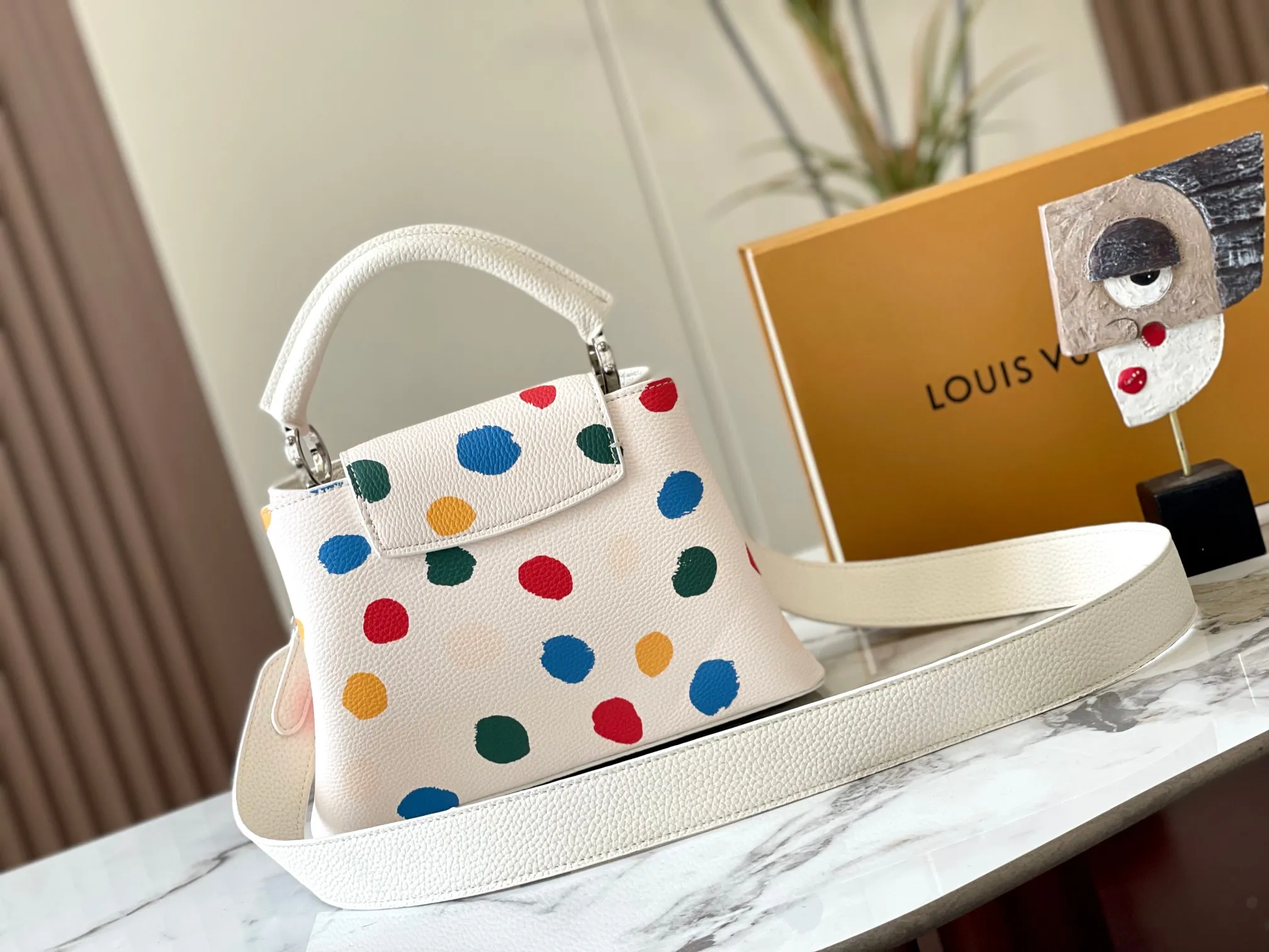 Upgraded version P440 M21663 This LV x YK Capucines small handbag comes from the Louis Vuitton x Yayoi Kusama collaboration series. The renowned Japanese artist has been obsessed with polka dots as a symbol of infinity since childhood, and finds a dazzling expression in supple Taurillon leather decorated with 3D hand-painted polka dot prints. Detailed features 27 x 18 x 9 cm (length x height x width)