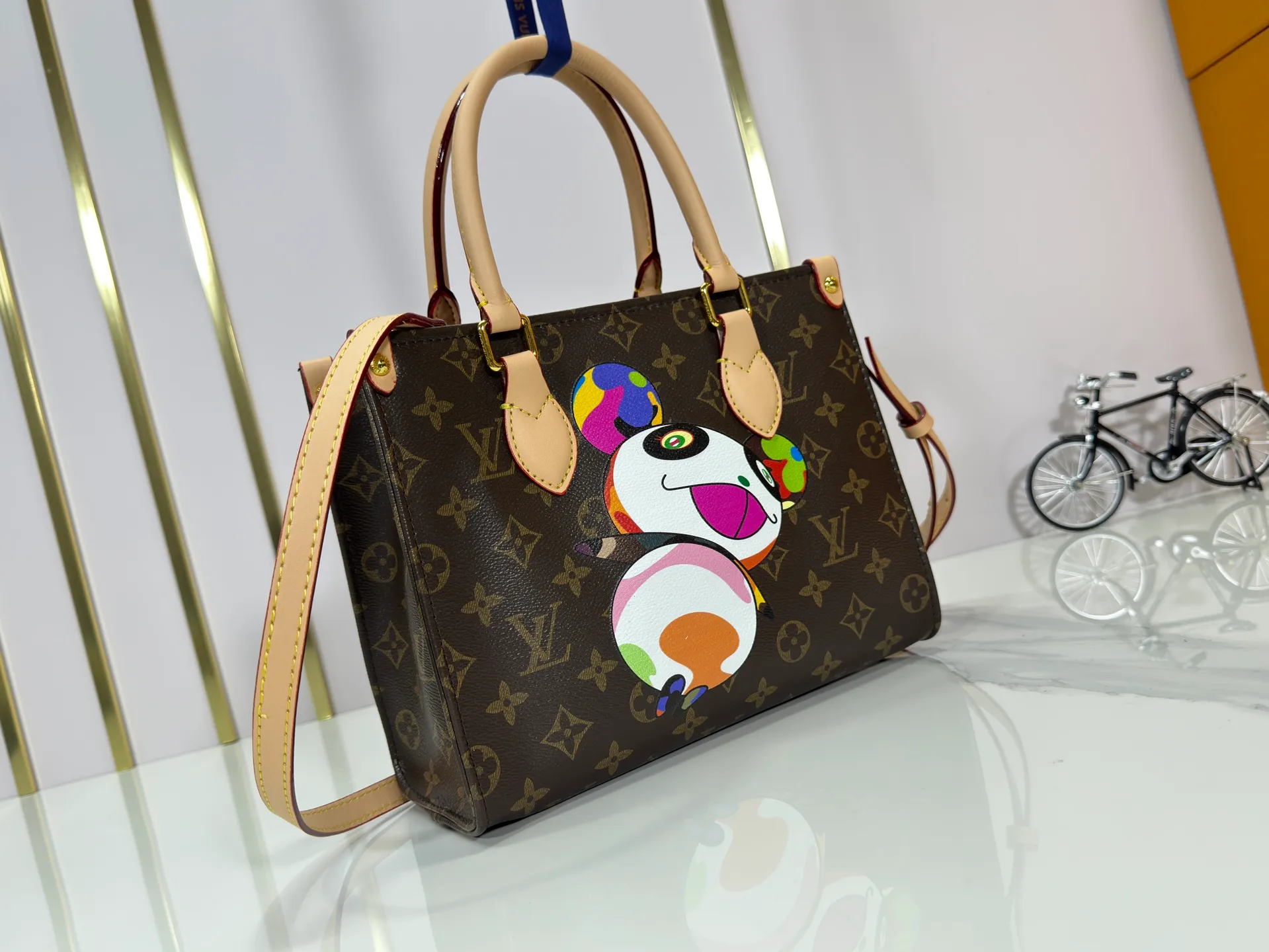 P240 upgraded original M45659 M46373 M13668 M44571 The Louis Vuitton x Murakami reissue series interprets the exquisite version of the OnTheGo handbag with playful touches. Monogram canvas and cow leather establish the brand's classic style, and Murakami's cute and cute panda image is transformed into front and back prints. The detachable and adjustable shoulder strap provides a variety of carrying options, and the zippered interior pocket keeps personal items safe and secure. Dimensions: 25.0 x 19.0 x 11.5 cm (length x height x width)