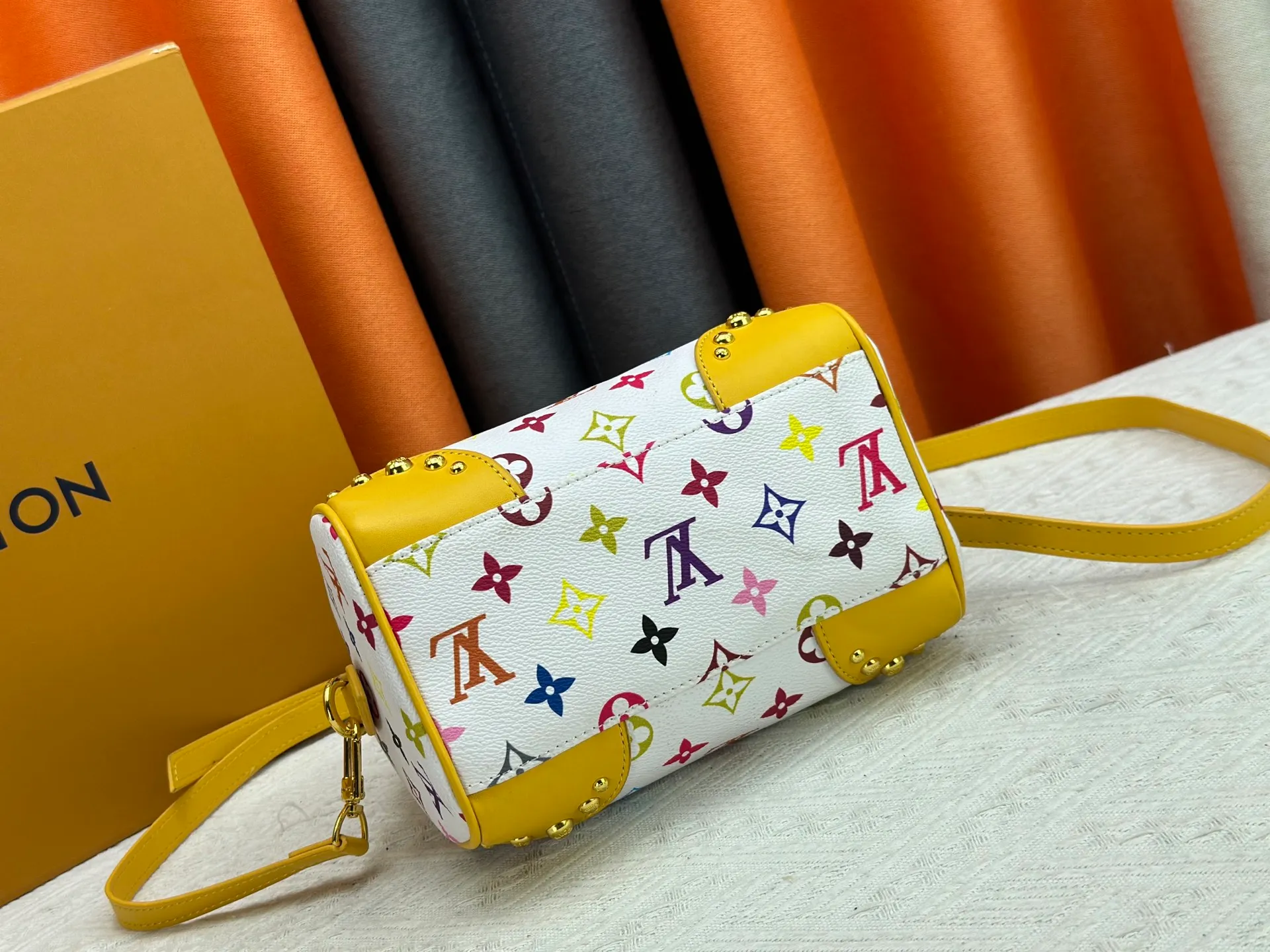 P260 upgraded original M58953 M46234 M46222 Speedy Bandoulière 20 handbag is made of soft coated canvas, and the full-length Monogram pattern is traced in colorful rainbow tones, highlighting the smart style of the Louis Vuitton x Murakami reissue series. The Toron handle and detachable shoulder strap are constructed of cow leather, the metal corners recall classic luggage elements, and the bow-shaped key bag and padlock add brand touches. Dimensions: 20.5 x 13.5 x 12.0 cm (length x height x width)