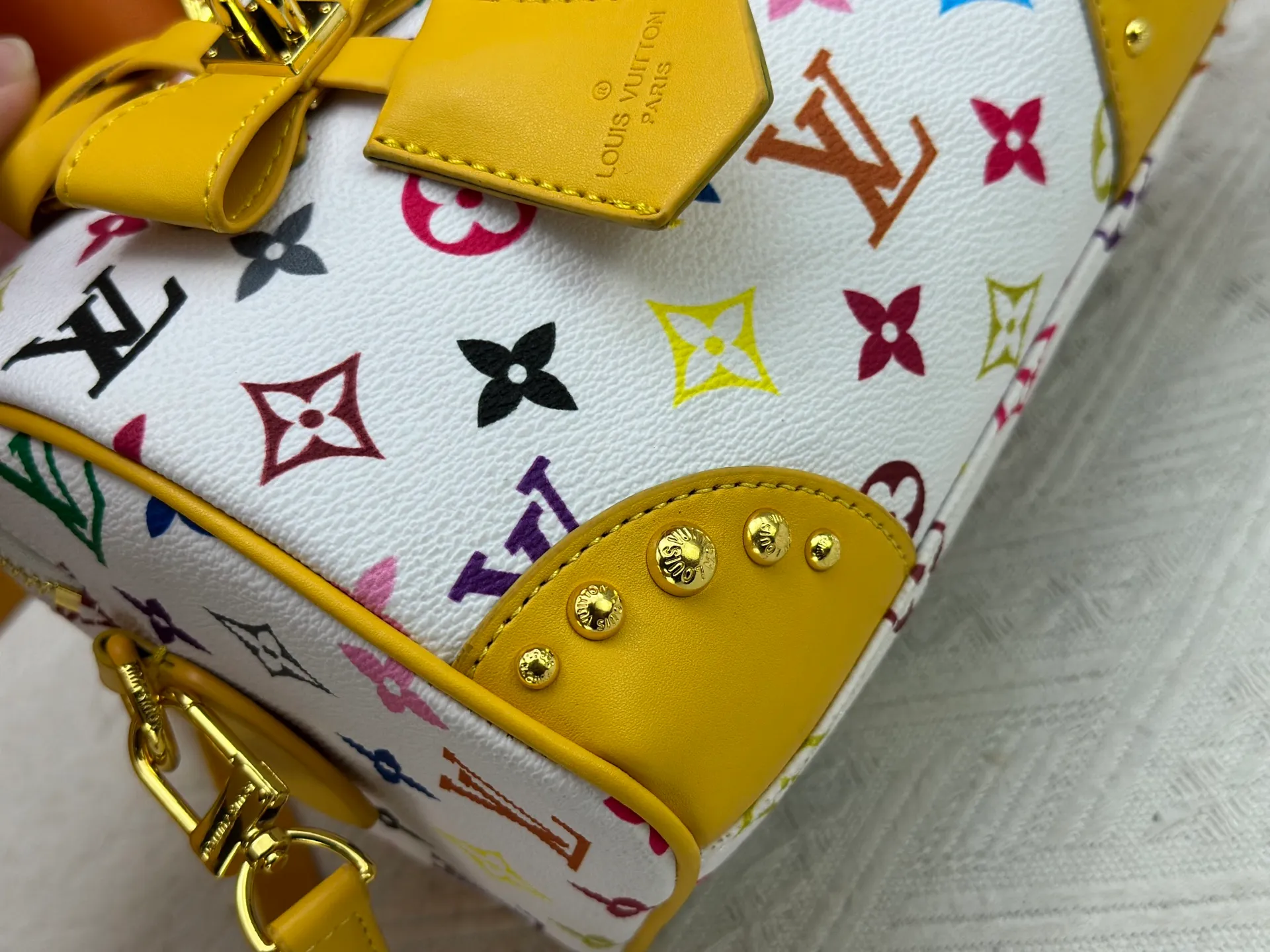 P260 upgraded original M58953 M46234 M46222 Speedy Bandoulière 20 handbag is made of soft coated canvas, and the full-length Monogram pattern is traced in colorful rainbow tones, highlighting the smart style of the Louis Vuitton x Murakami reissue series. The Toron handle and detachable shoulder strap are constructed of cow leather, the metal corners recall classic luggage elements, and the bow-shaped key bag and padlock add brand touches. Dimensions: 20.5 x 13.5 x 12.0 cm (length x height x width)