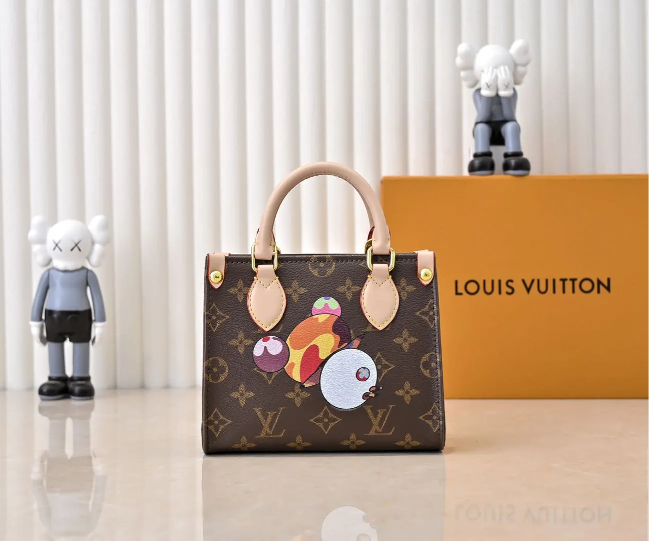Batch 280💰M46993 M13668!🔥Lv&Takashi Murakami🐼Panda Print OnTheGo BB New Version The legendary ONTHEGO handbag: always able to meet your various needs for handbags. It has a large capacity but is not bulky. It is stiff and soft to the touch, making it suitable for home and travel. Tighten the side ties and it instantly transforms into a stylish urban handbag. Loosen the straps and it transforms into a chic and practical handbag. The slender leather handle can be carried over the shoulder or between the arms. The model shown here is made of Damier Azur canvas. Size: 18x15x8.5cm
