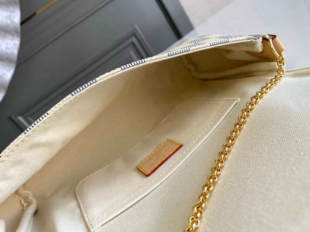 💰640 Top original order N41275 FAVORITE MM This Favorite MM handbag is the darling of fashionable women. It is sewn with bright Damier Azur canvas and is suitable for morning and evening occasions. The bag can be used as a clutch, or can be carried as a short shoulder bag using the gold chain strap, while the leather shoulder strap can be easily carried cross-body. An engraved metal plaque on the front conceals a clever magnetic closure for safe access. Details 26 x 15 x 4 cm (length x height x width) Damier Azur coated canvas Natural cowhide leather trim Textile lining Gold-tone hardware Magnetic flap closure Internal patch pocket Shoulder strap: non-detachable, not adjustable Strap vertical height: 52.0 cm Chain strap: detachable