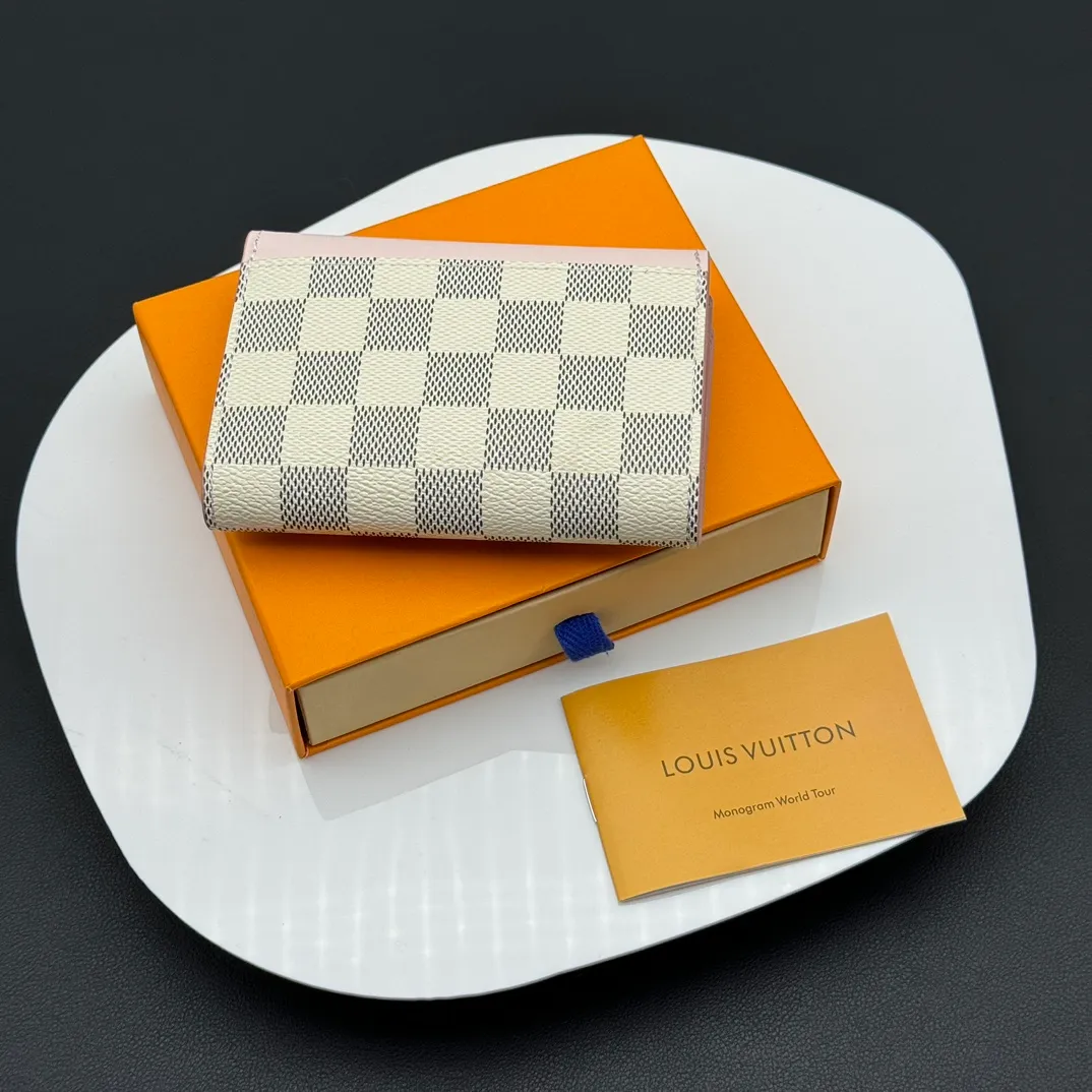 💰130 💎Upgraded original version🇫🇷 ZOÉ Wallet The Zoé wallet combines Damier Azur canvas and pastel leather to outline an envelope-like structure. The flip cover is decorated with gold Louis Vuitton snaps to welcome the coolness of summer. The compact design hides ample space, making it easy to store coins, banknotes and bank cards. It can also be placed in a pocket, handbag or clutch. Model: M60168 Dimensions: 9.5 x 7.5 x 3.0 cm (length x height x width).