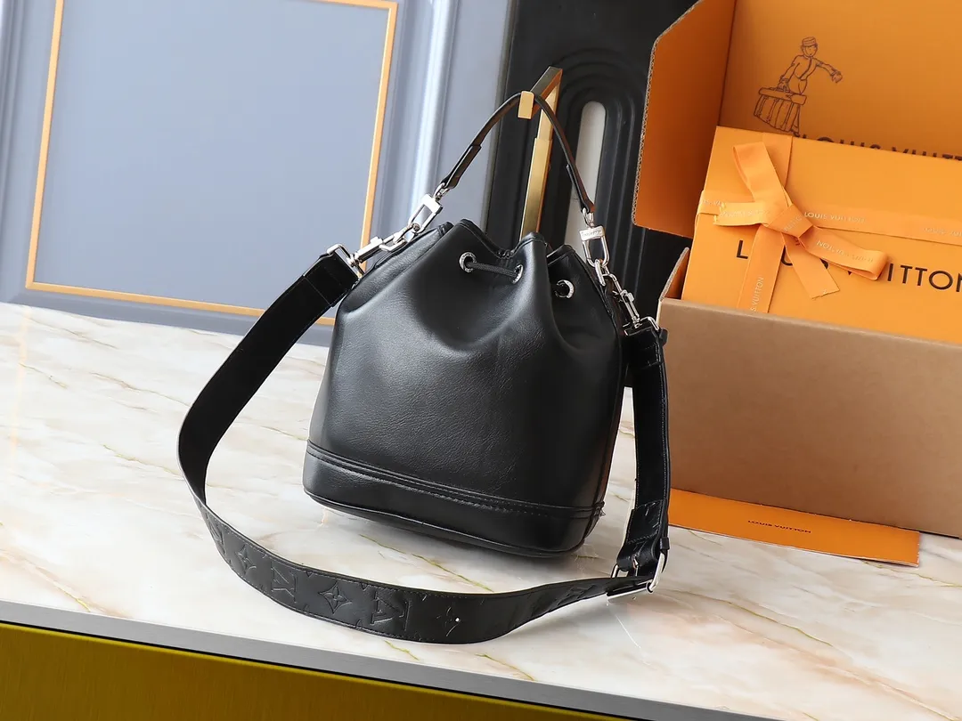 💰260💰Upgraded original M13985 full leather black, official small size M14017 pure presbyopic Noe Cargo is a compact bucket bag, made of shiny cow leather, showing a nylon-like technological luster, and the lining is made of deep-toned fabric. Metal parts, including the LV letters attached to a ball chain, are the only color-coordinated elements on this monochromatic bag. Roomy front pocket inside. ·Cow leather trim fabric lined with hardware Drawstring and metal closure main compartment LV pendant zip puller ·Pearl rivets Louis Vuitton Paris patch ·Zip front pocket Shoulder strap: Removable, adjustable strap Half length: 40.0 cm Dimensions: 24✘22✘16cm (H✘L✘W)