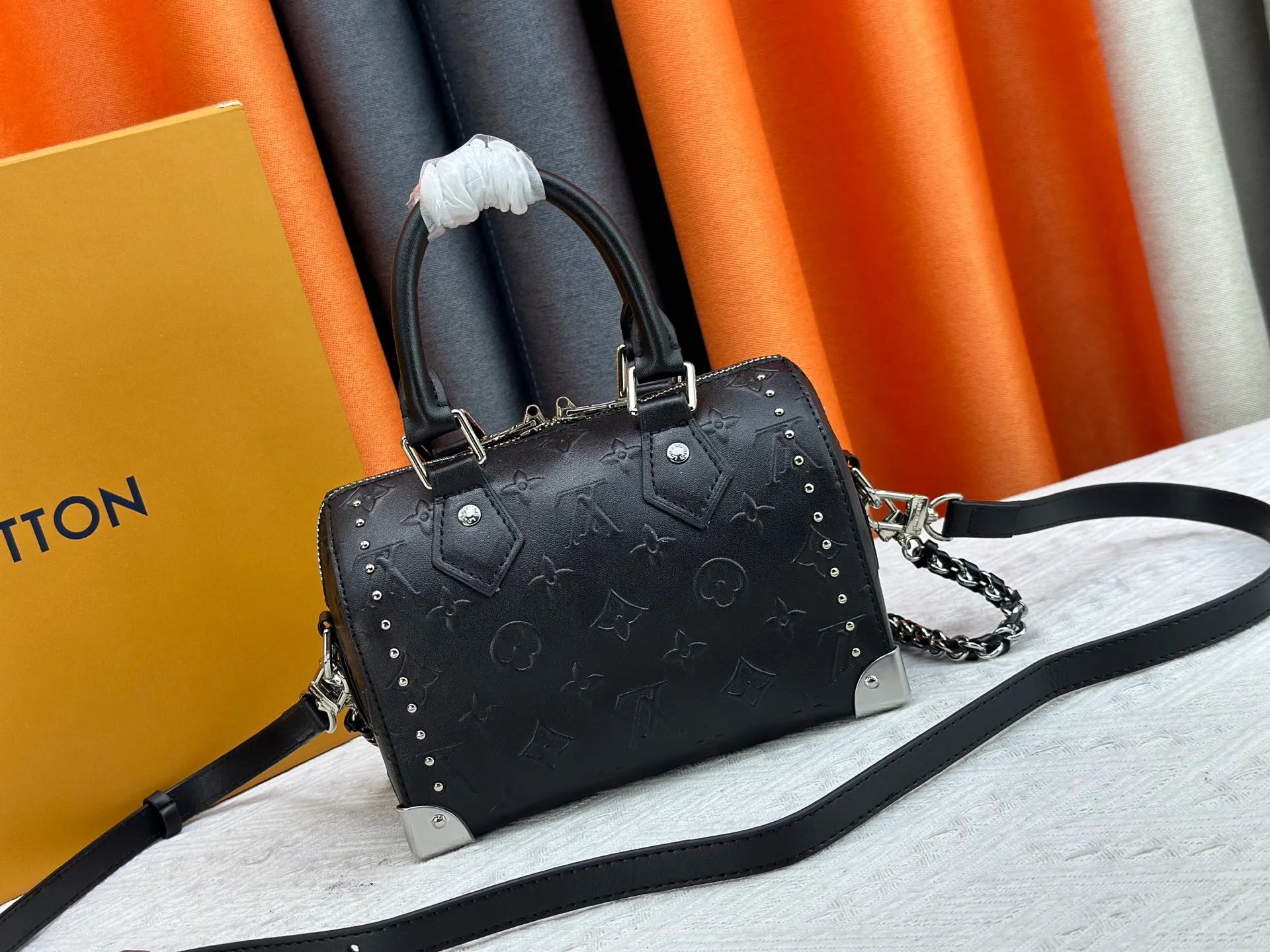 The P300 M13146 M14575 Speedy Trunk handbag reimagines the classic design with a bold concept and made an eye-catching appearance at the Louis Vuitton 2025 Cruise early spring show. Monogram canvas with Monogram Reverse trim shows Nicolas Ghesquière’s signature brushwork, and the dazzling metal hardware pays homage to the brand’s long trunk-making heritage. The shoulder strap and chain are detachable and can be worn cross-body, over the shoulder or by hand. Detailed Features 20.5x16 x11 cm (Length x Height x Width) Monogram canvas Cow leather trim Fabric lining Metal hardware Padlock Internal patch pocket Chain: Removable Chain half length: 13.0 cm Handle: Double handle